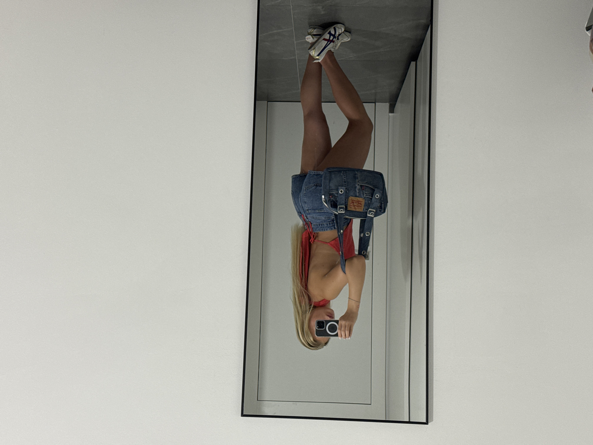 Woman takes mirror selfie in Ariel room