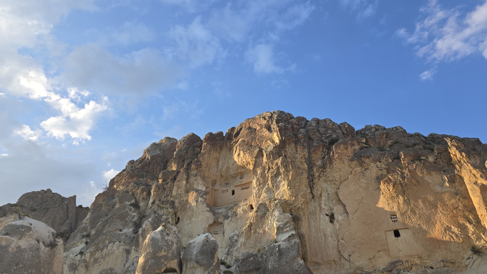 Dramatic cliff formation captured under bright blue sky