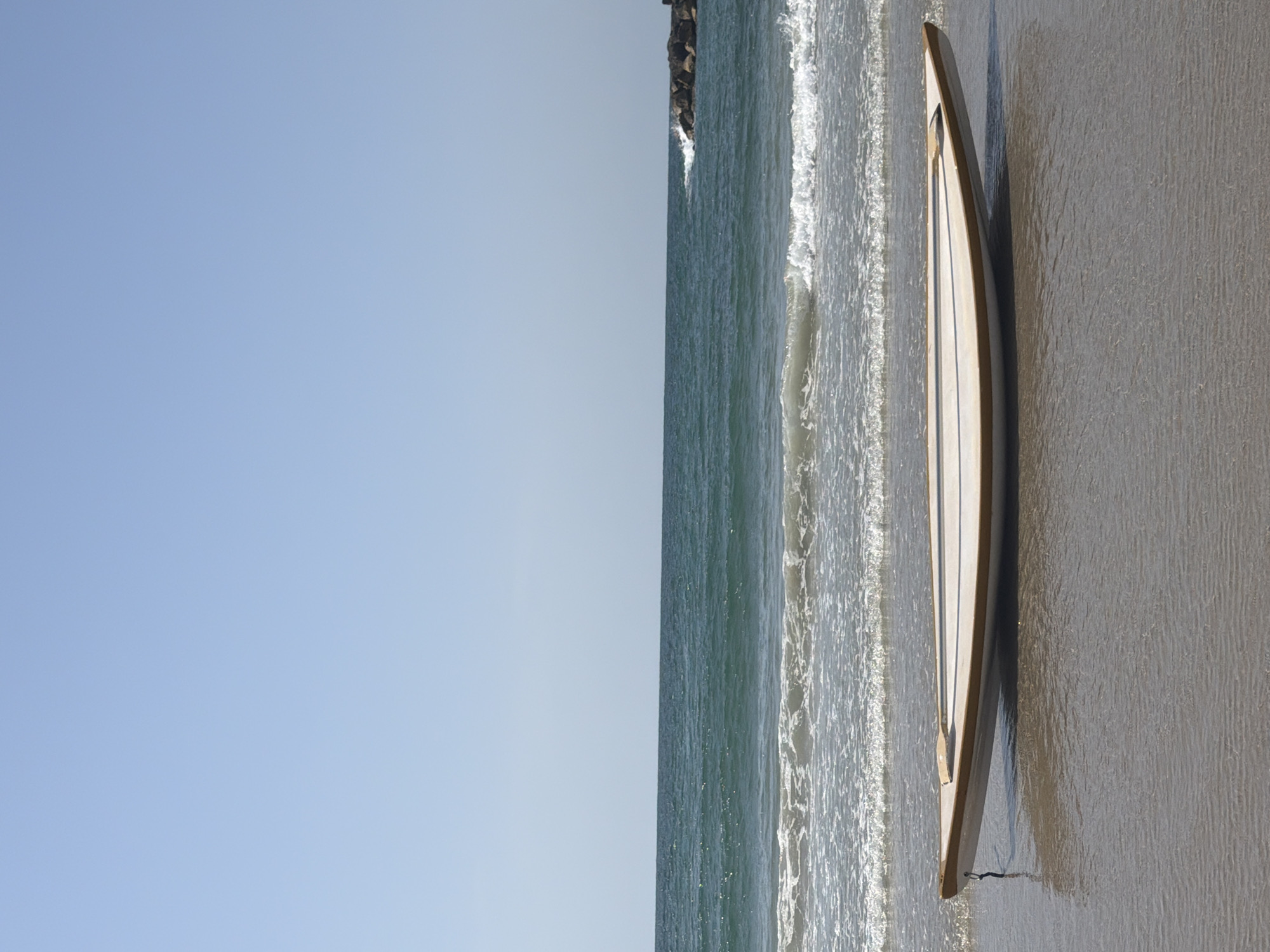 Surfboard spotted on Tel Aviv beach under clear skies