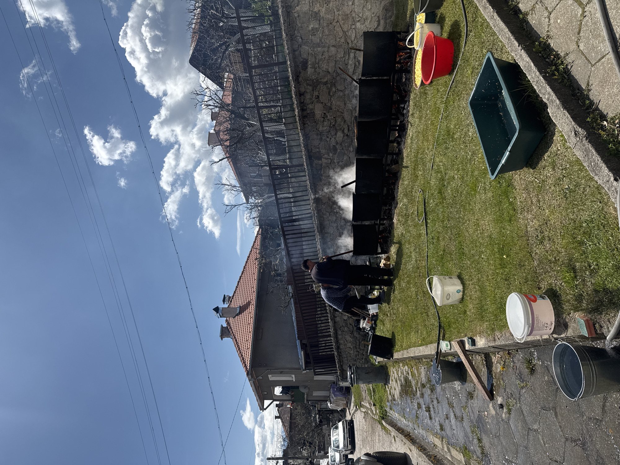 Two men tend fire with containers in Dobarsko