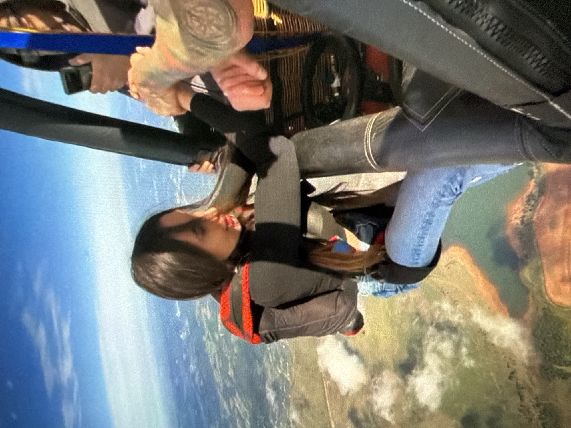 Group skydiving operation captured during helicopter jumps over city