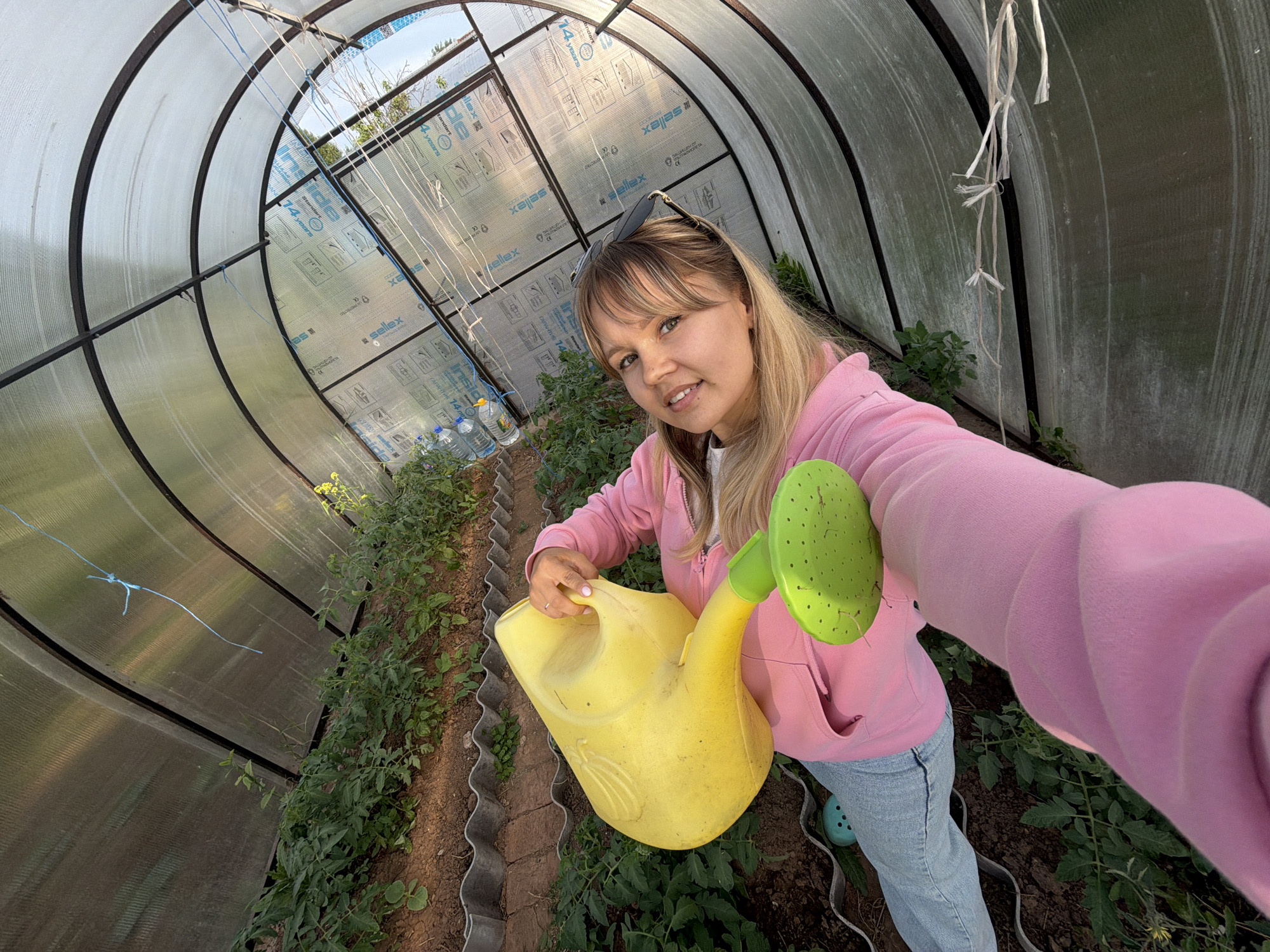 Woman documents greenhouse gardening session with pets in rural Russia