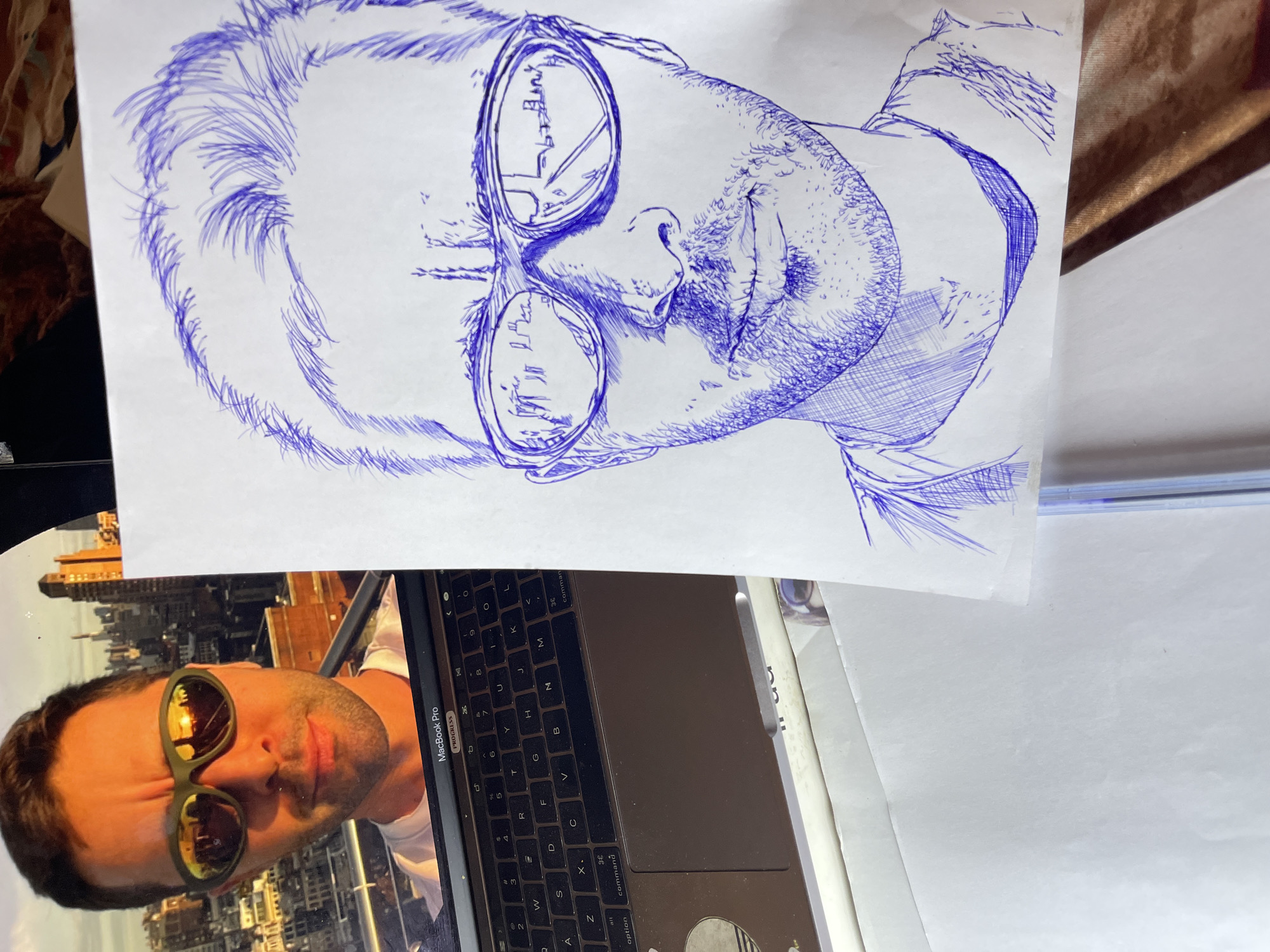 Artist sketches portrait series in blue ink in Jos