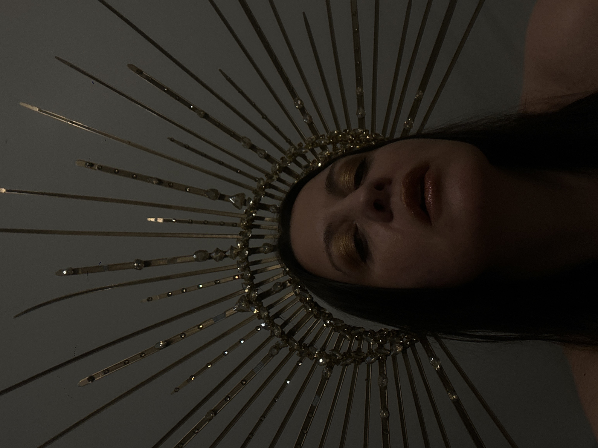 Person in golden crown photographed in elaborate portrait session