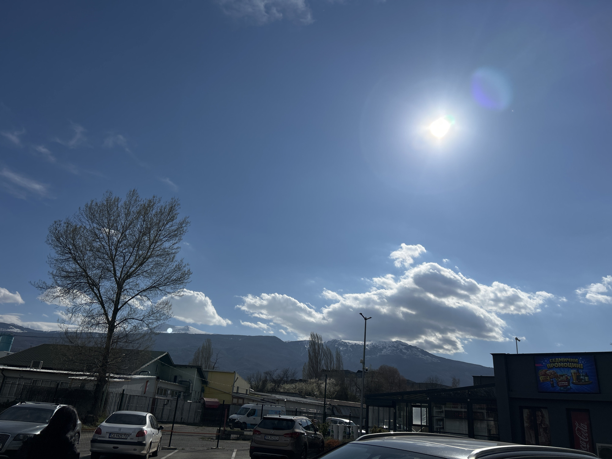 Urban landscape with parking, plants, mountains documented April 7