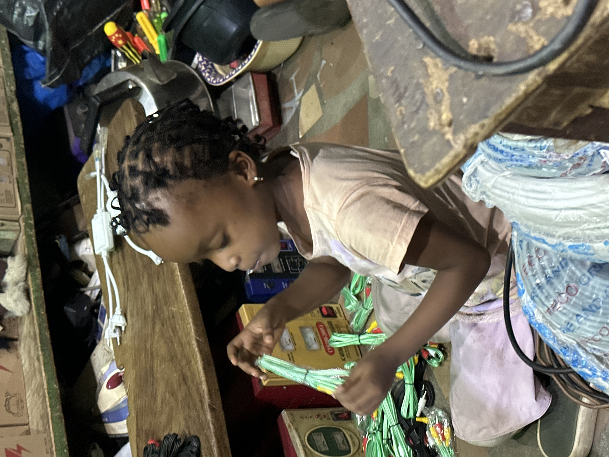 Sitting among clutter in a Narayi market or storage space