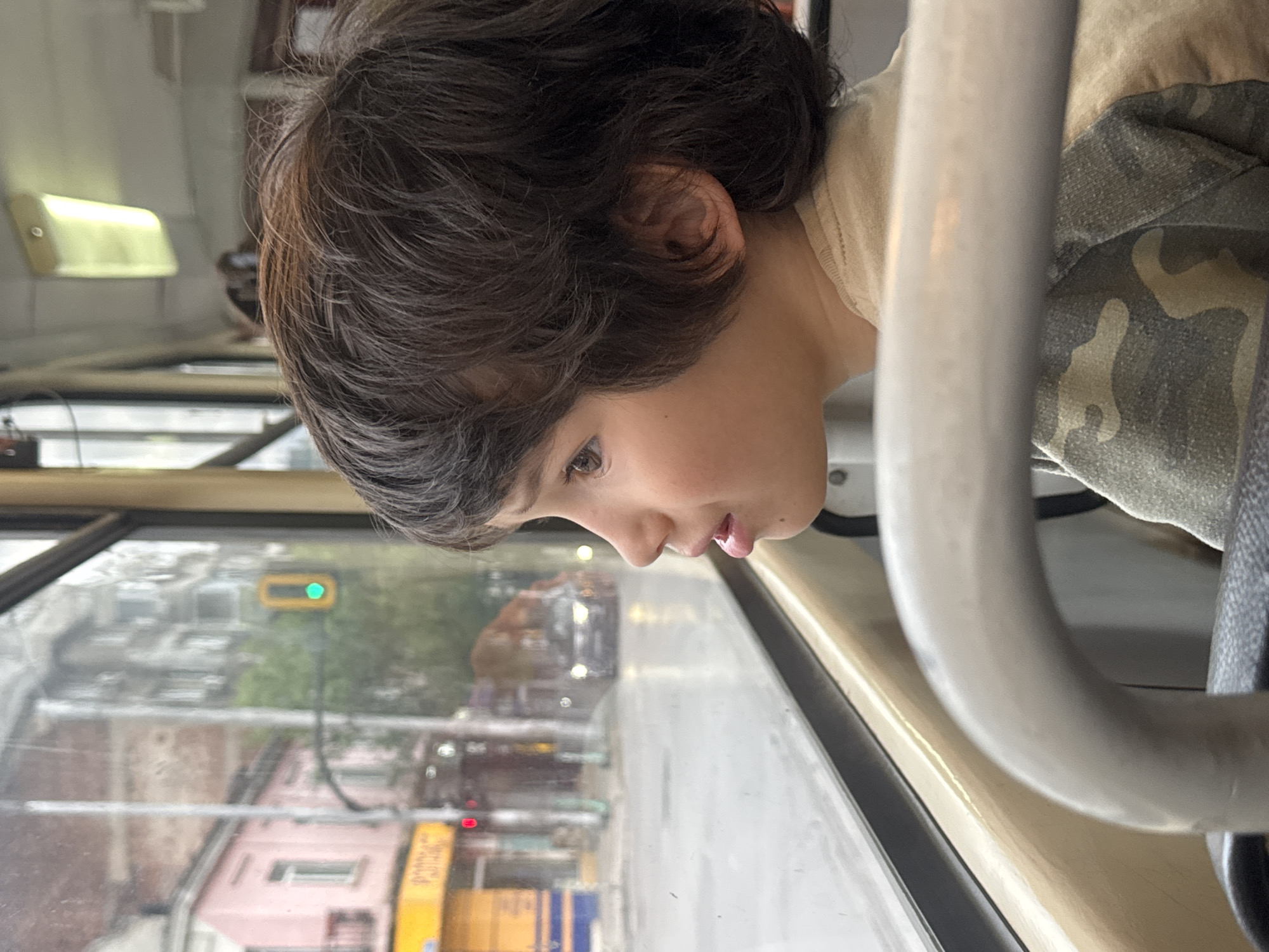 Boy gazes from bus window in Sofia street scene