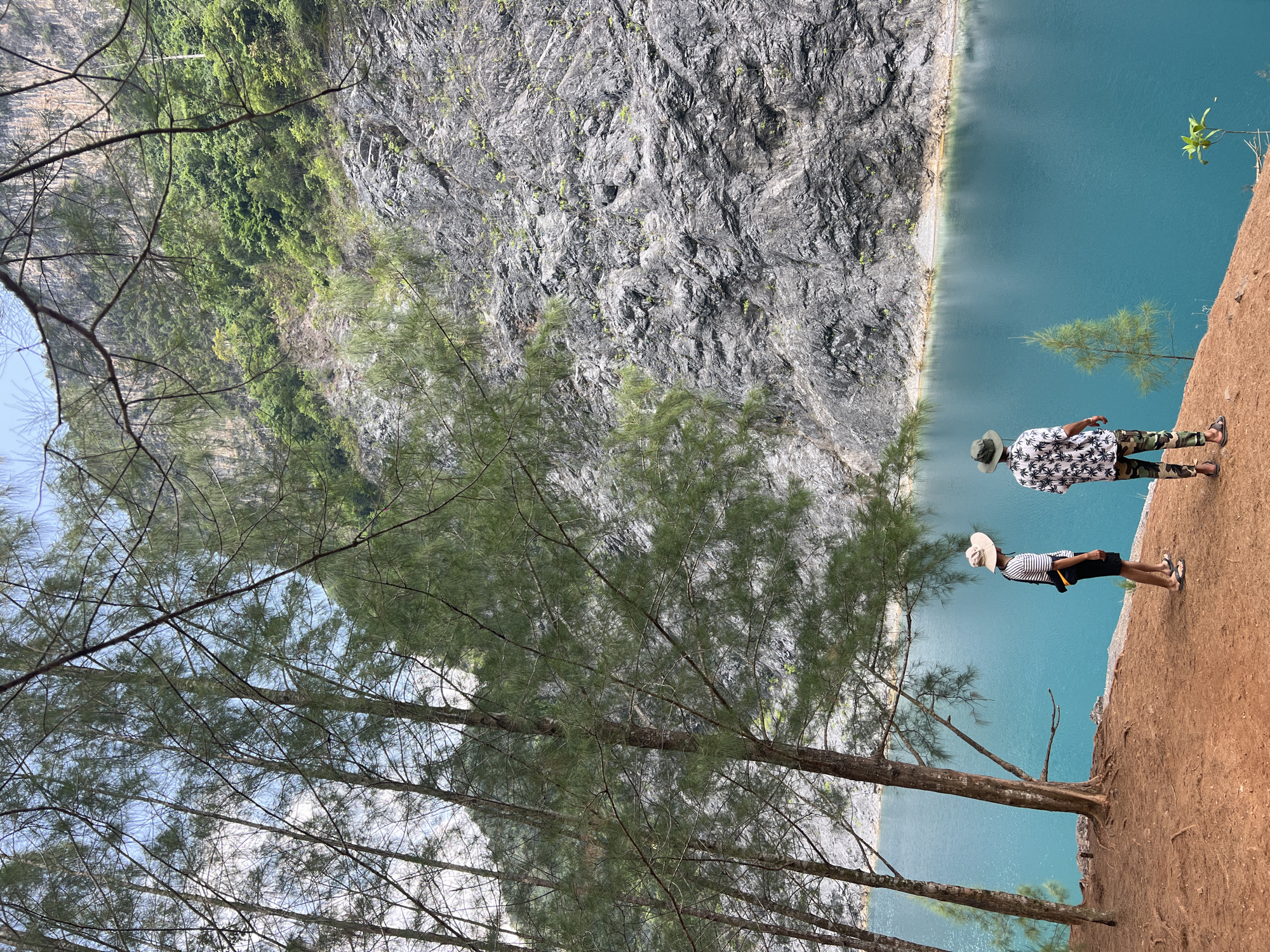 Visitors view blue waters from cliff overlook in Ban Nai Wang