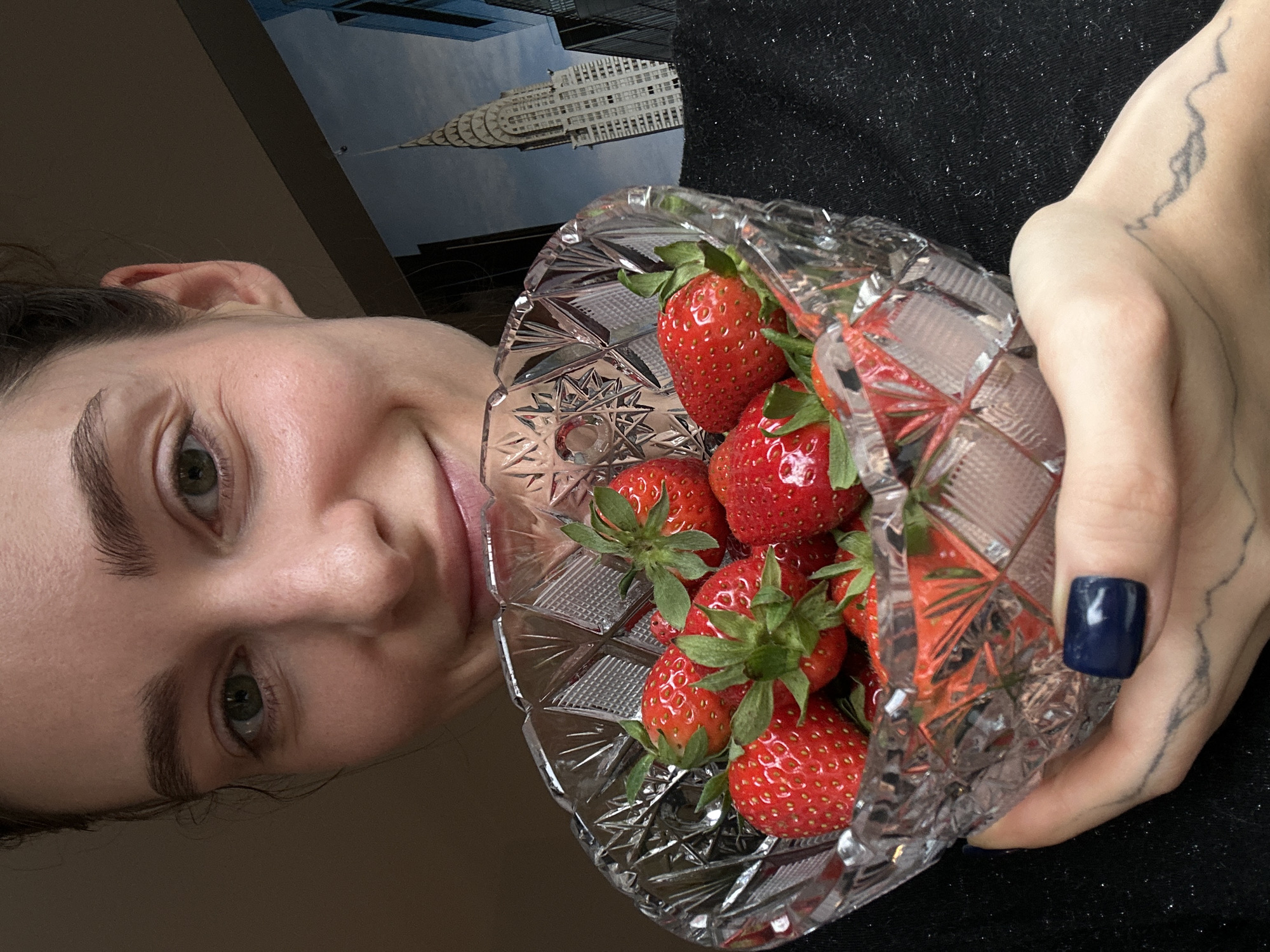 Person photographs strawberry and candy arrangement in crystal bowls