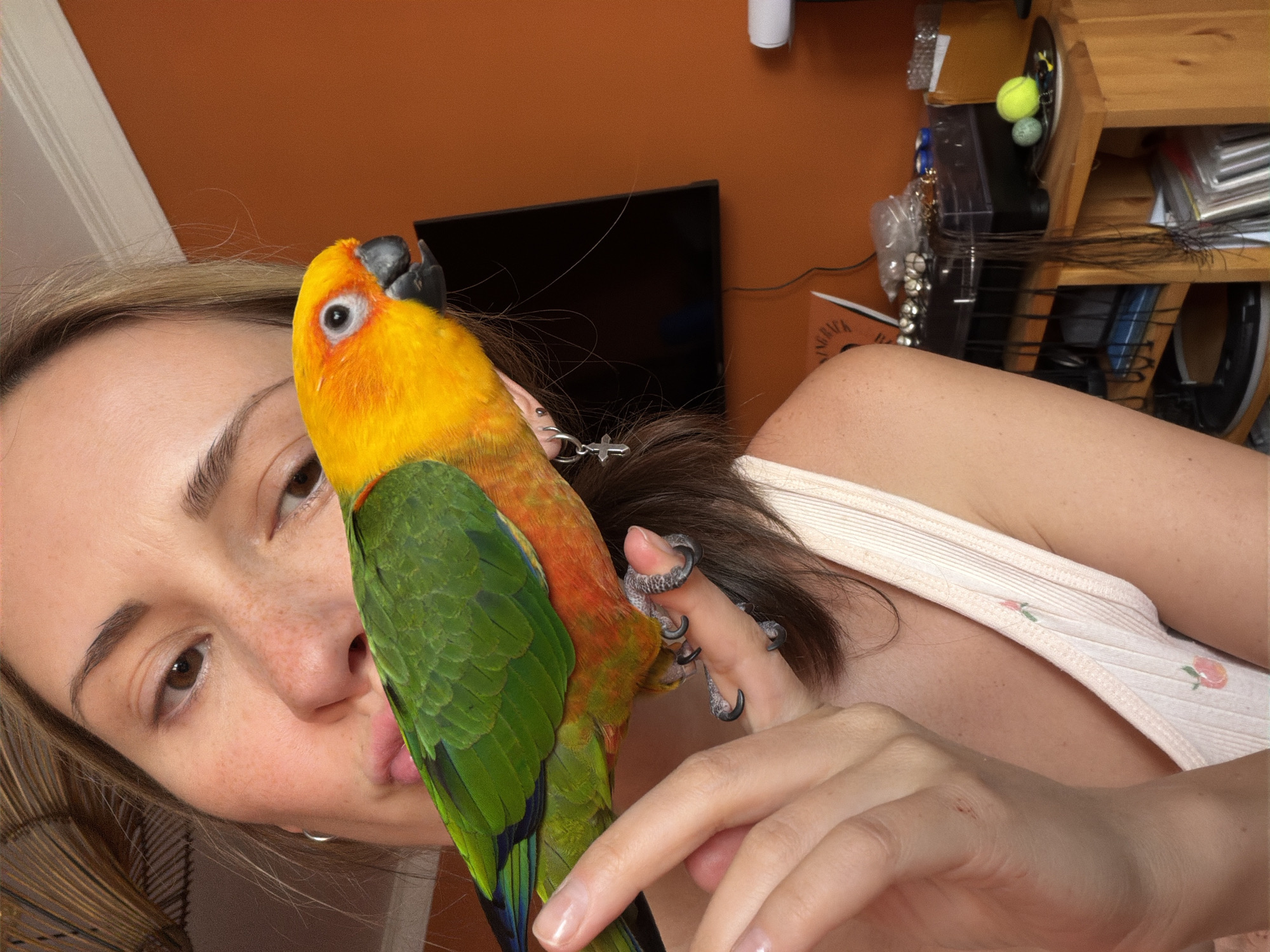 Woman poses with colorful parrot in casual photo session
