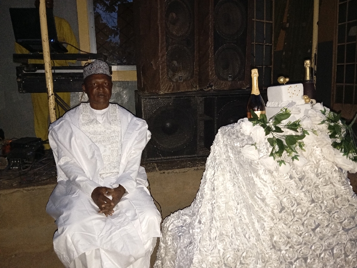 Man in traditional dress observed at table in Nigeria