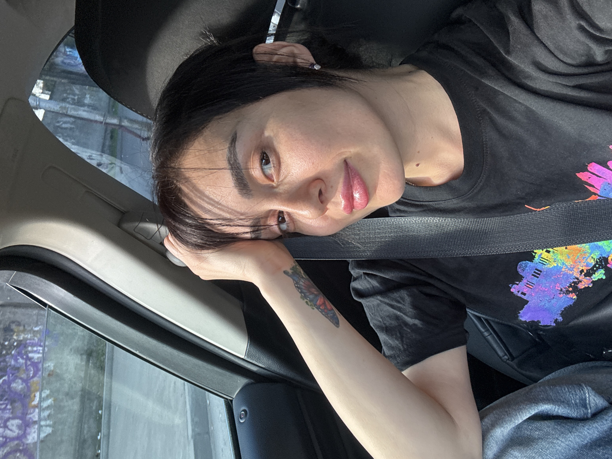 Woman rests in passenger seat during car ride in Tbilisi