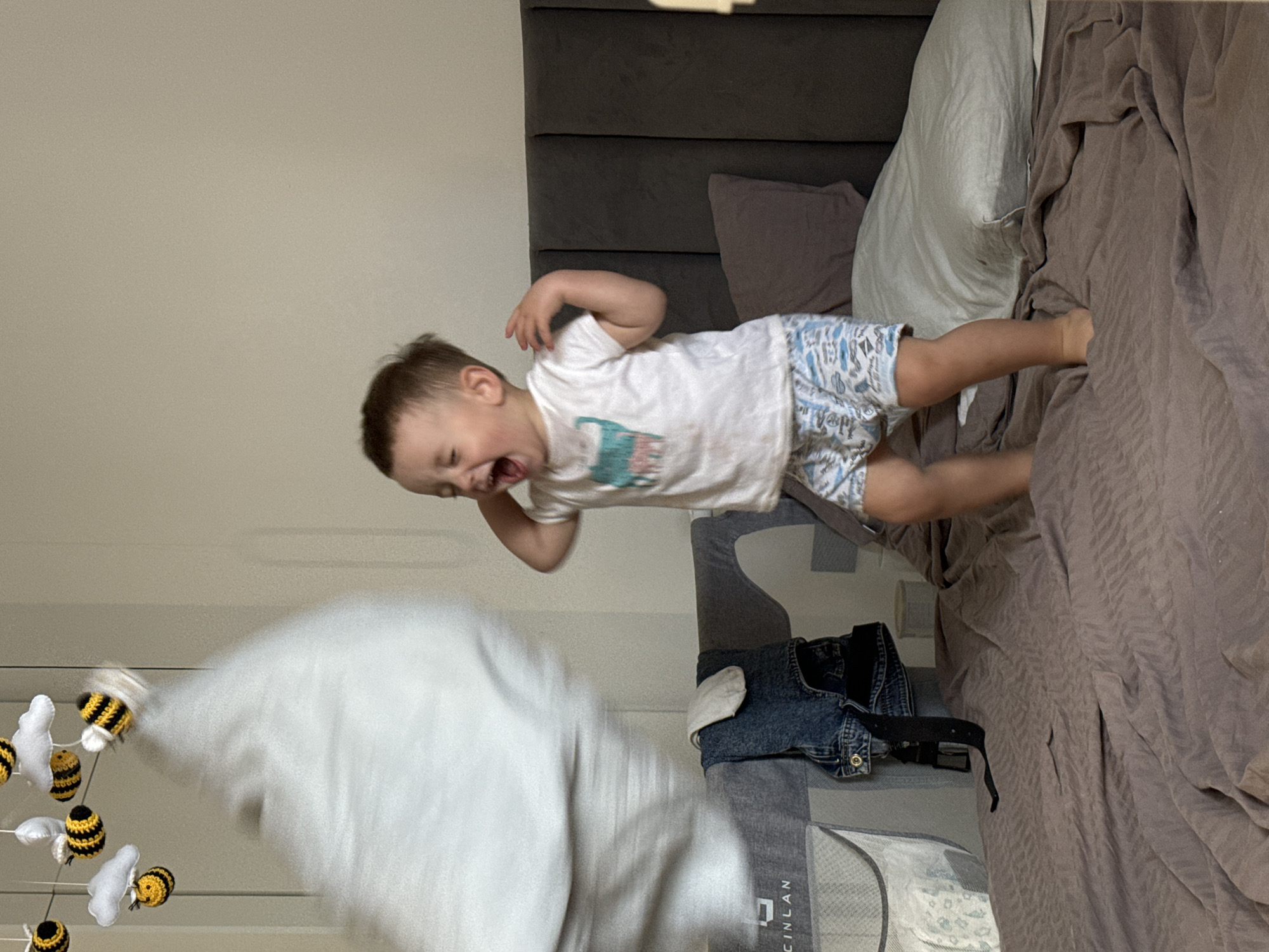 Toddler jumps on bed in Odintsovo bedroom