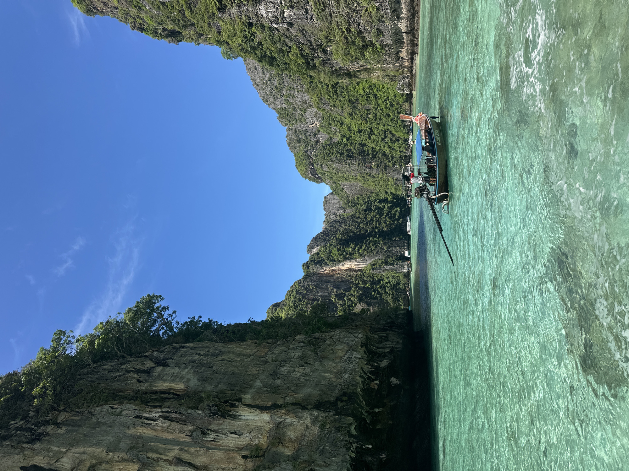 Long-tail boat anchored in a turquoise Haad Yao cove