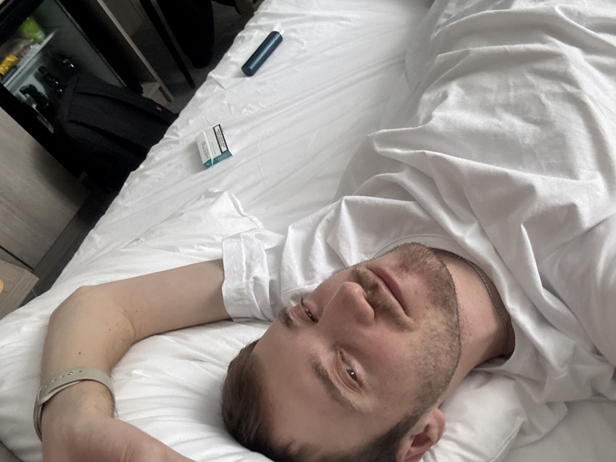 Man rests in bed with personal items in Russia