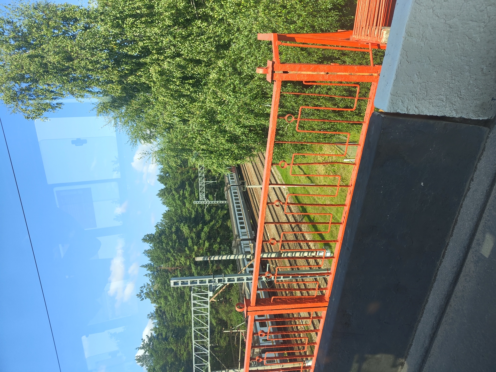 Trains and buses moving through Ramenskoye on a July morning