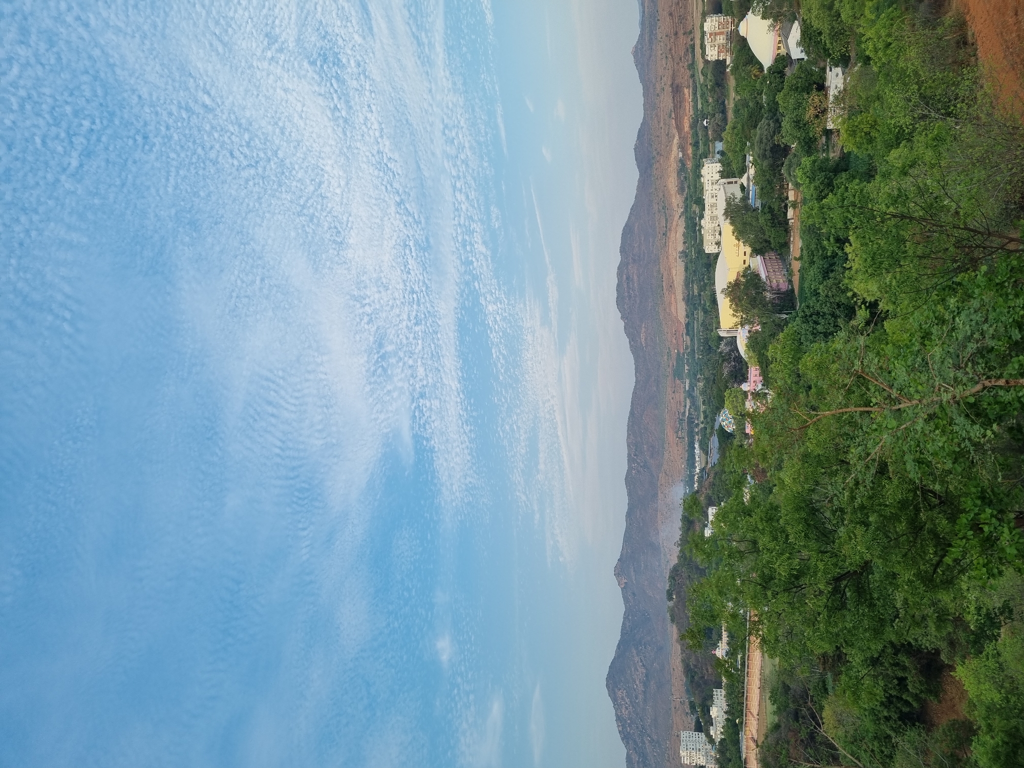 Elevated daytime view of clouds and mountains in Puttaparthi