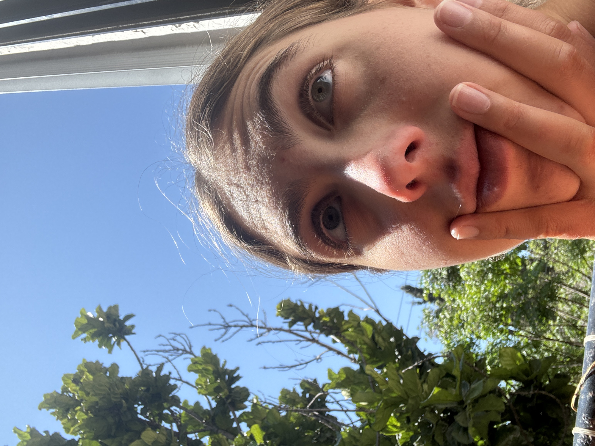 Person takes selfie with hand covering face in Givatayim