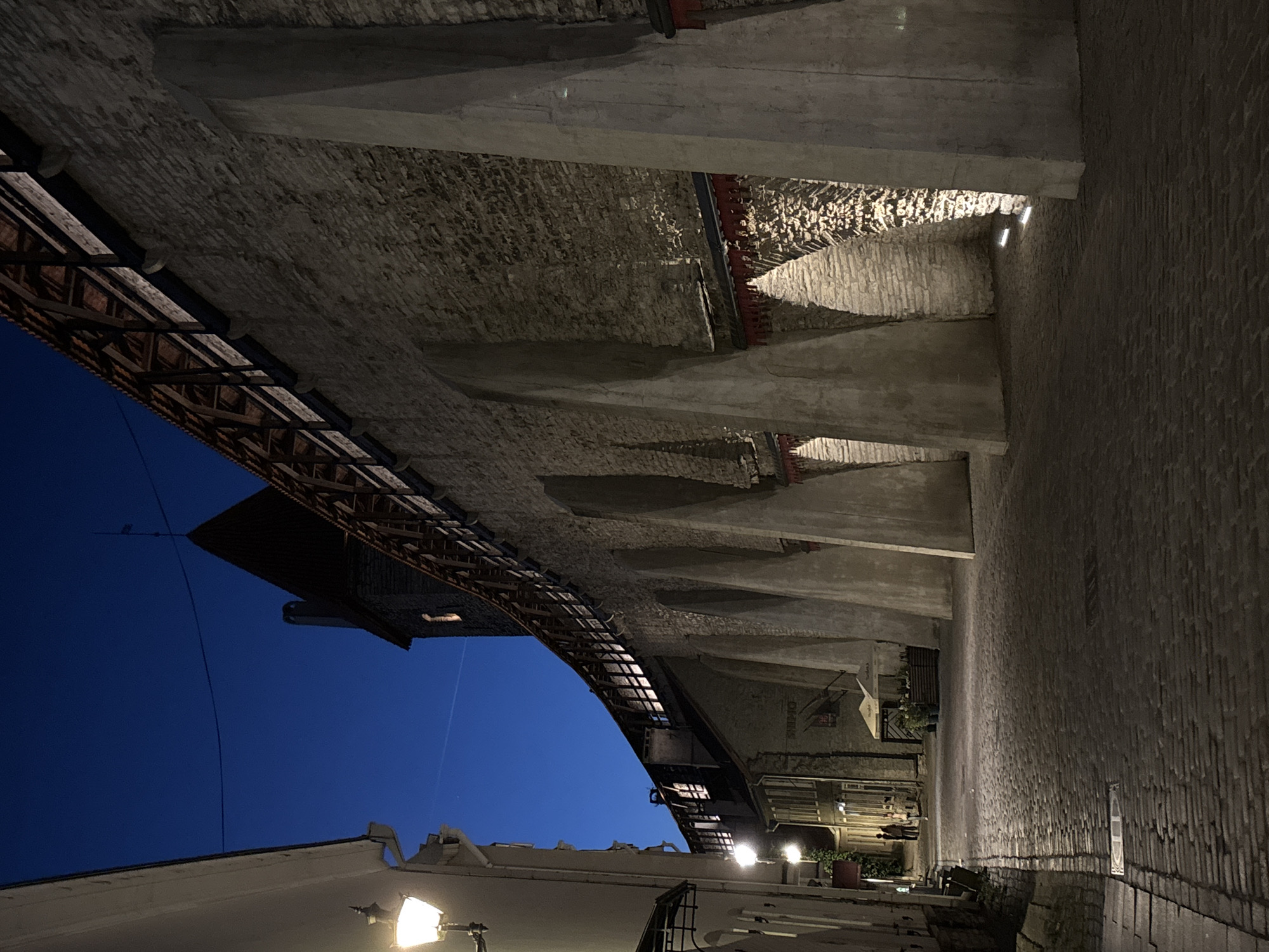 Tallinn Old Town at night — cobblestones, walls, and a rustic storefront