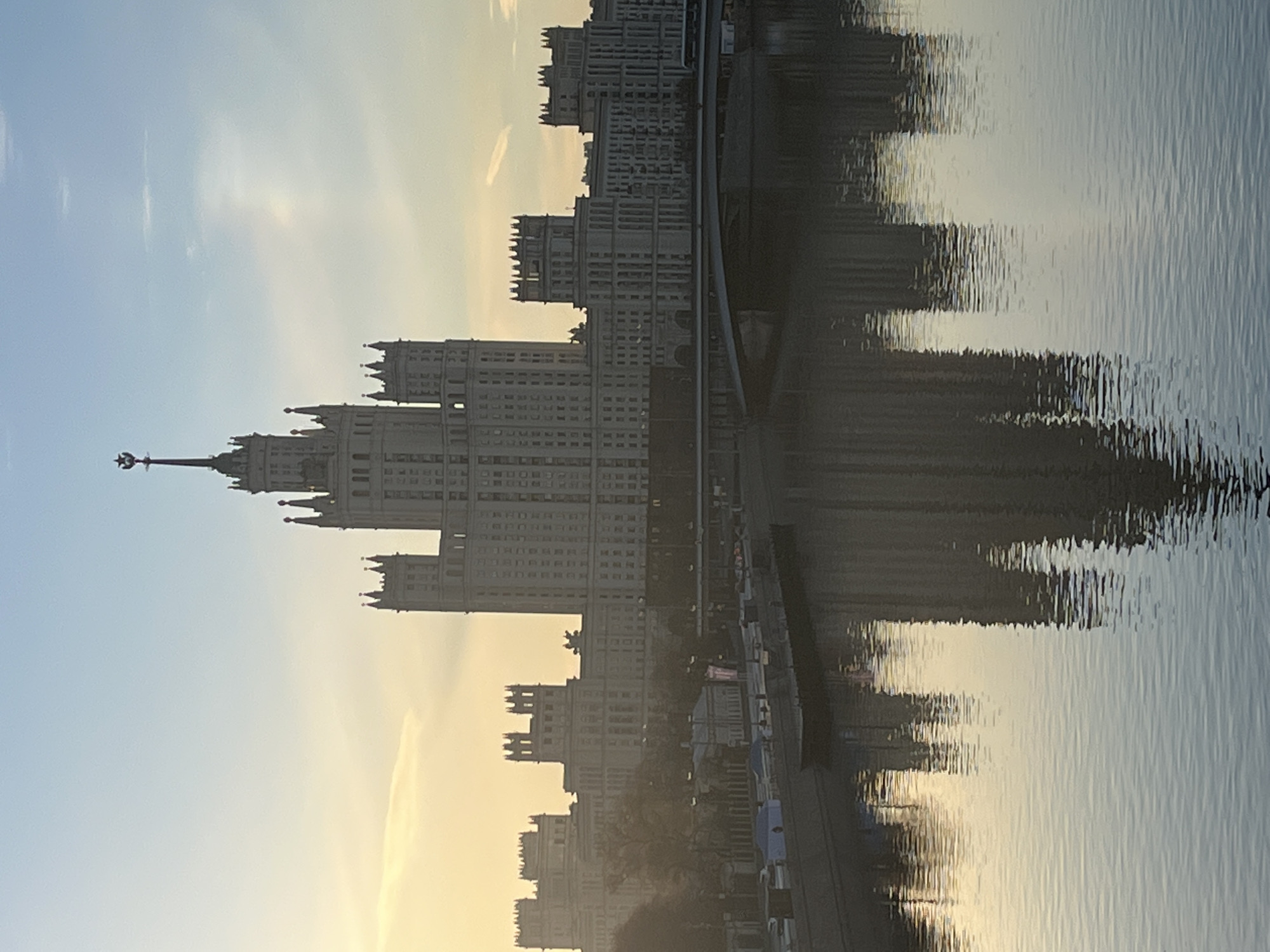 Seven Sisters skyscraper reflected in Moscow River at sunset