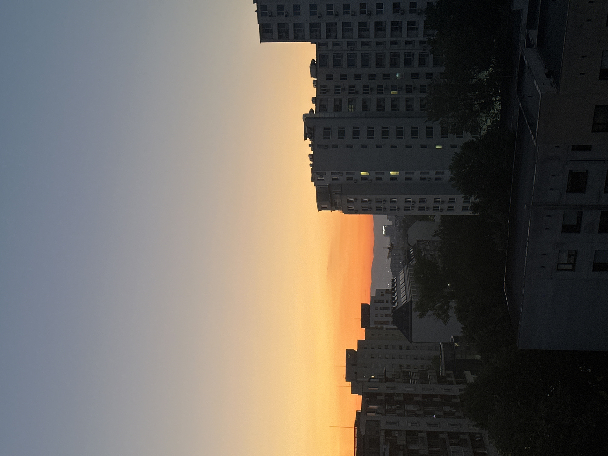 Twilight documented over Sofia apartment buildings with crescent moon visible