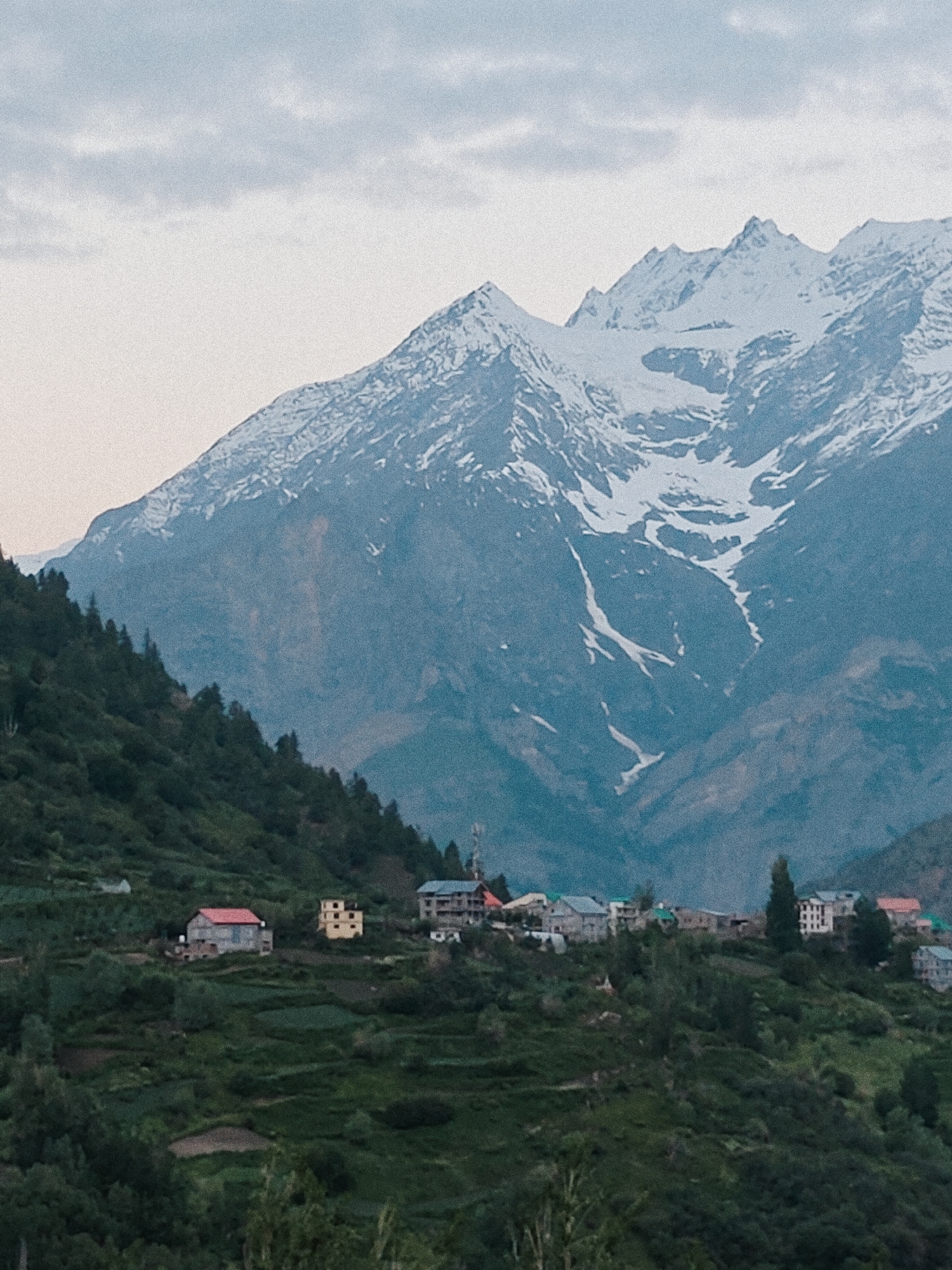 Evening stop in Keylong, Himalayas — town, peaks, and a motorcycle