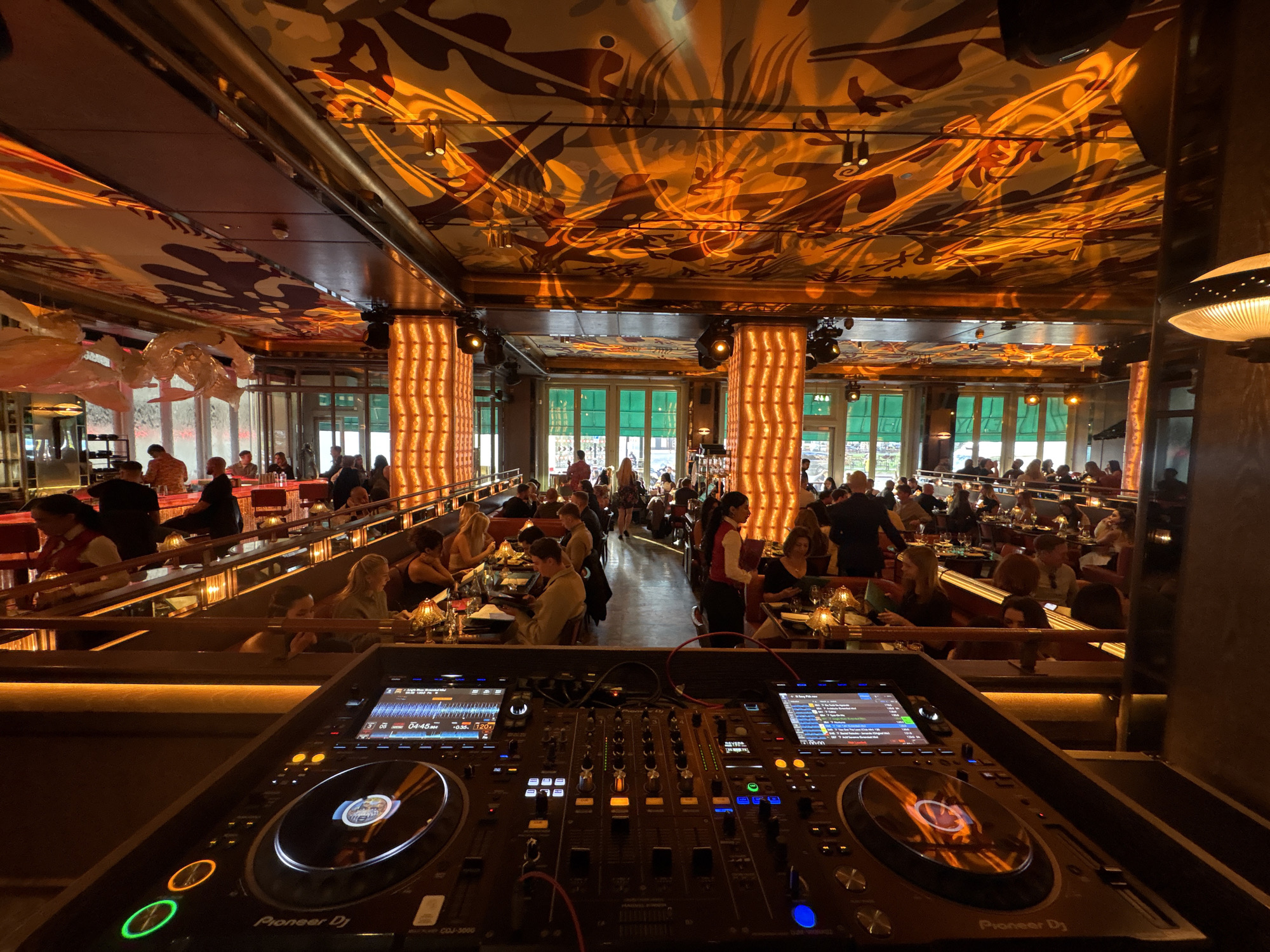 Female DJ performs at crowded London restaurant-bar venue