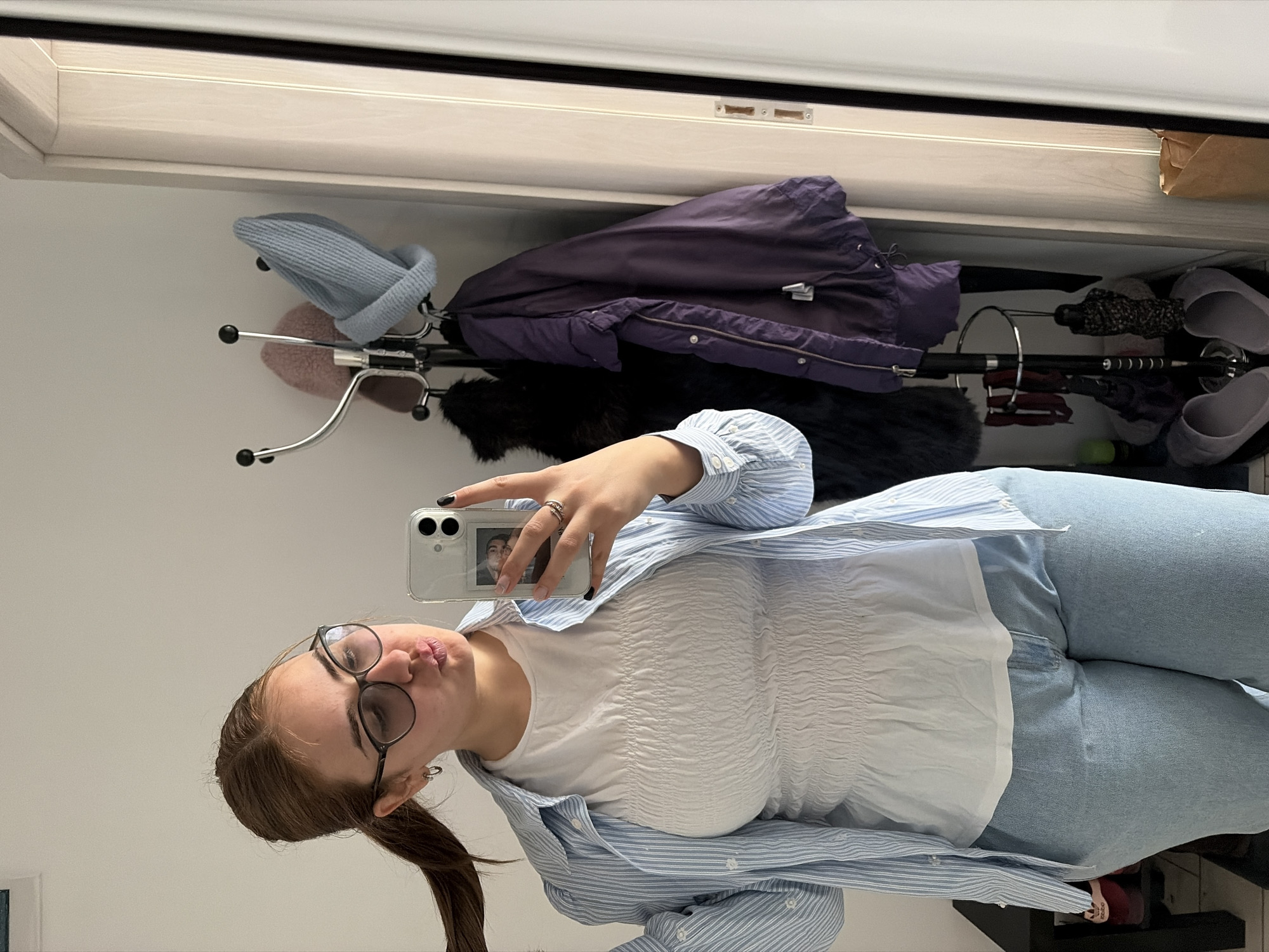 Person takes mirror selfie in casual outfit