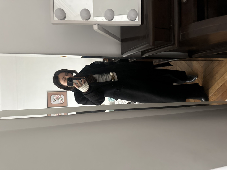 Woman takes mirror selfie in Paris clothing store