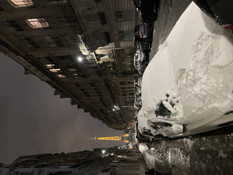 Nighttime Paris street scene captures illuminated Eiffel Tower