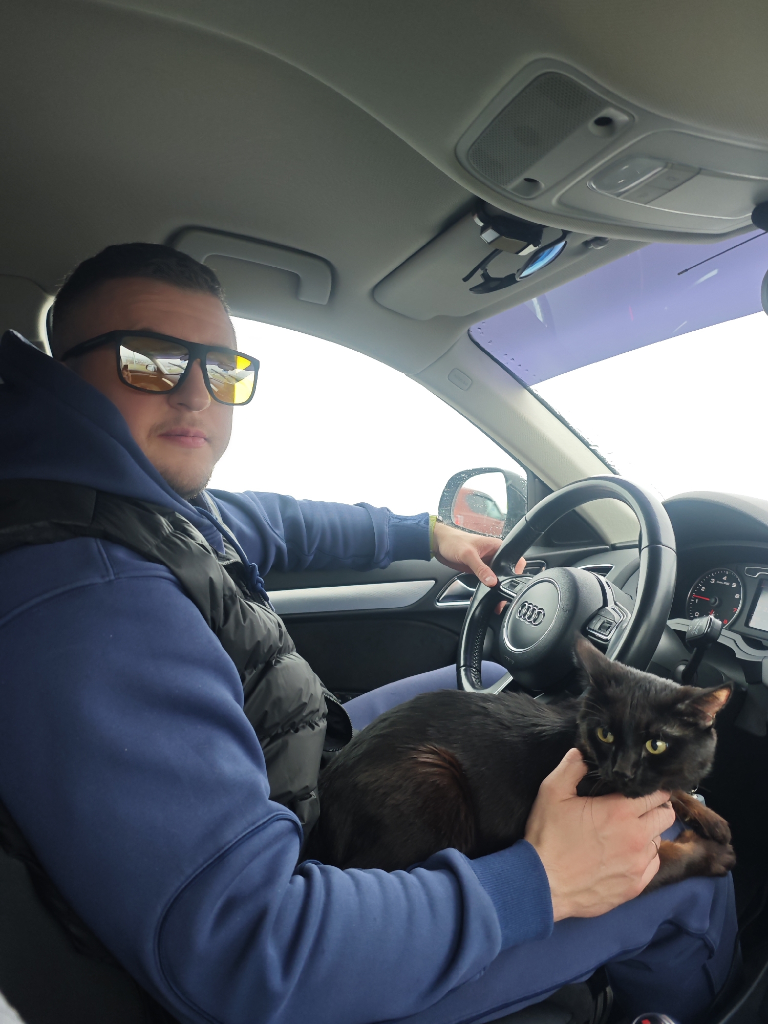 Man holds cat while sitting in car in Chaikovsky, Russia