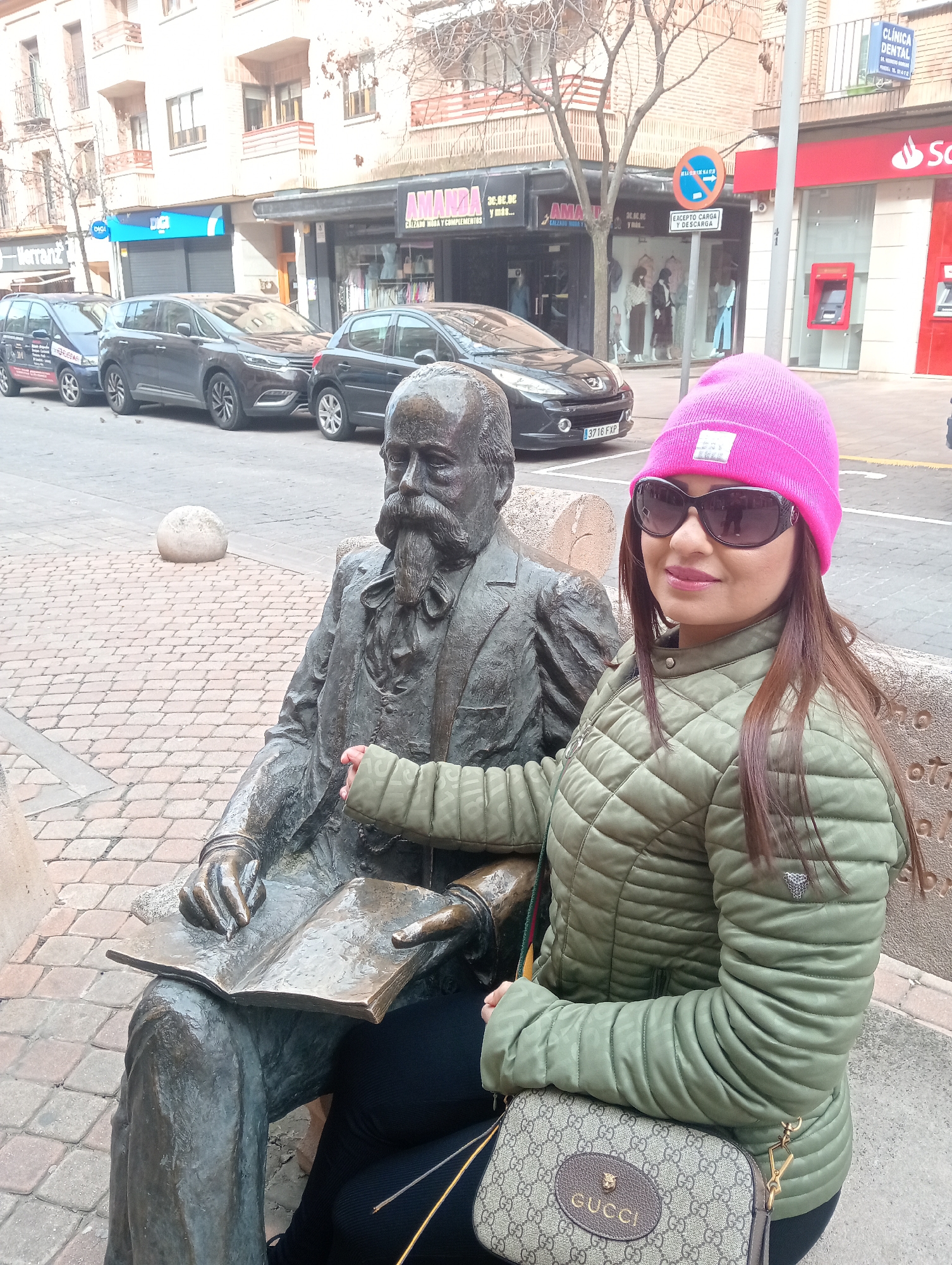 Tourist poses with bronze statue in Segovia streets