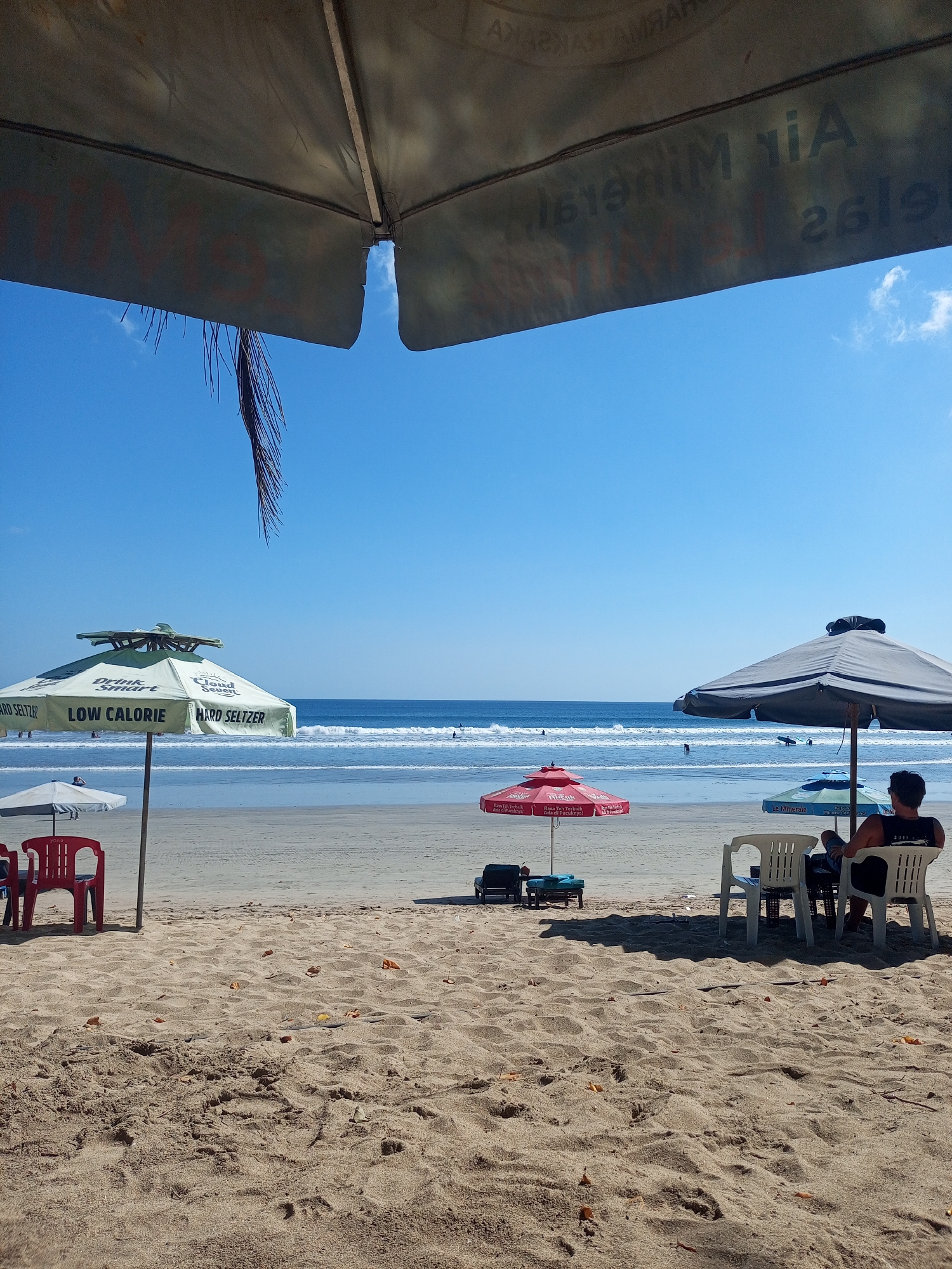 Kuta Beach morning: surf racks, sand, and takeout noodles