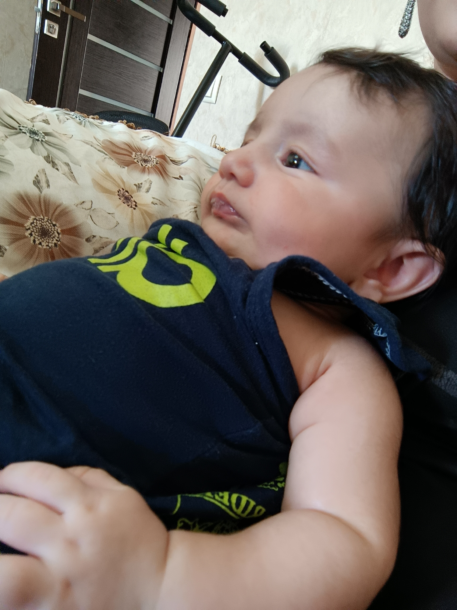 Baby in dark blue shirt gazes upward, Yerevan