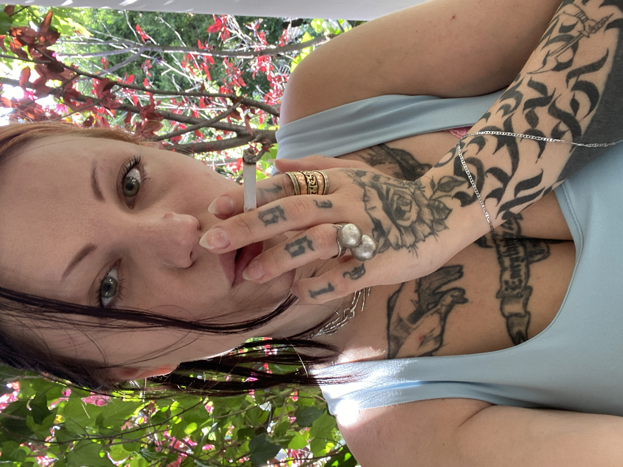 Tattooed woman smoking cigarette observed in Kunje, Montenegro