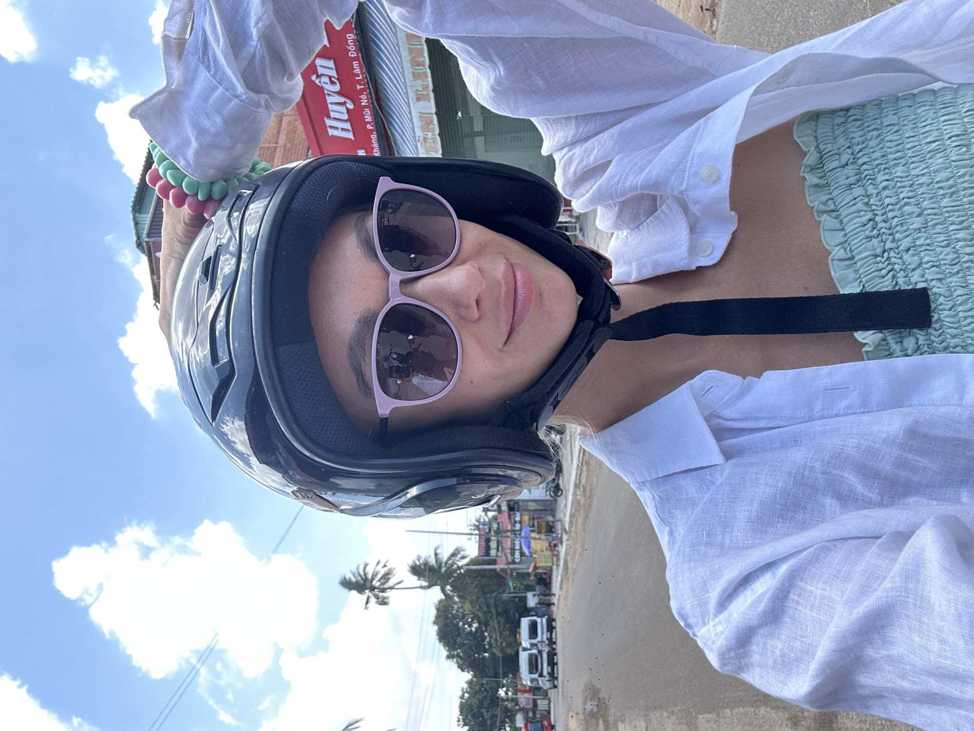 Woman in motorcycle helmet takes selfie in Mũi Né