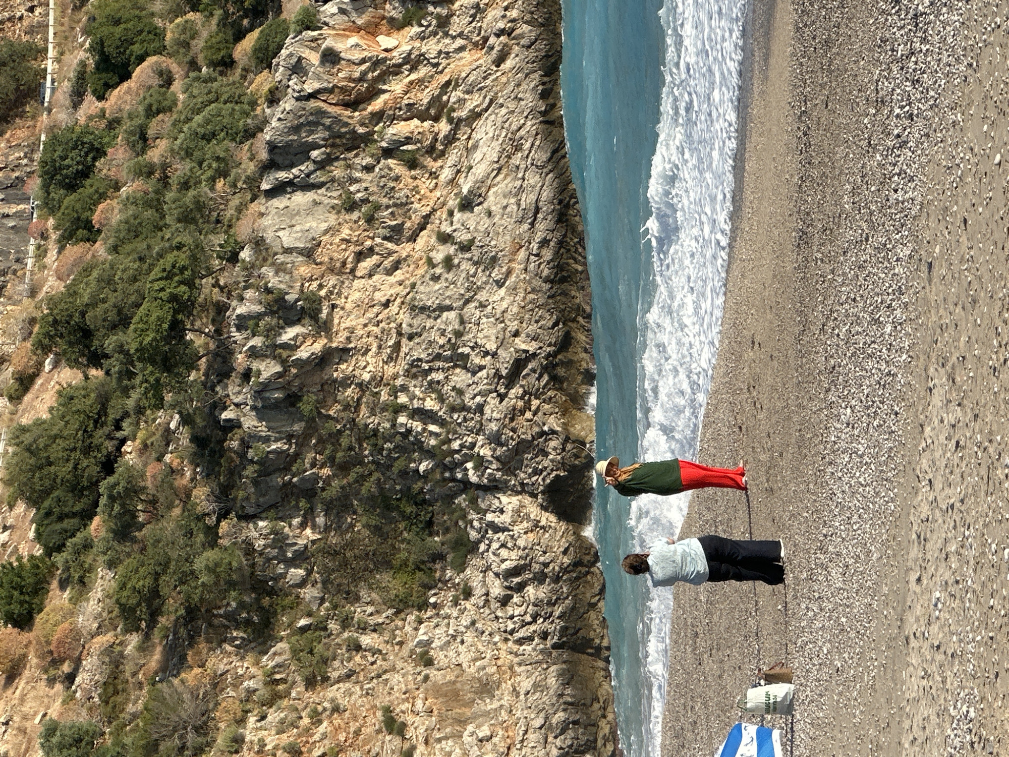 Man collects driftwood on Turkish beach in Fethiye