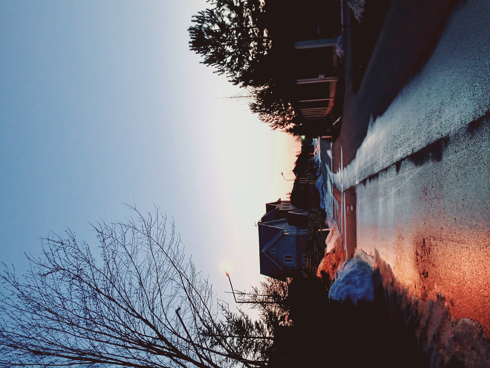 Residential neighborhood observed during spring twilight with melting snow