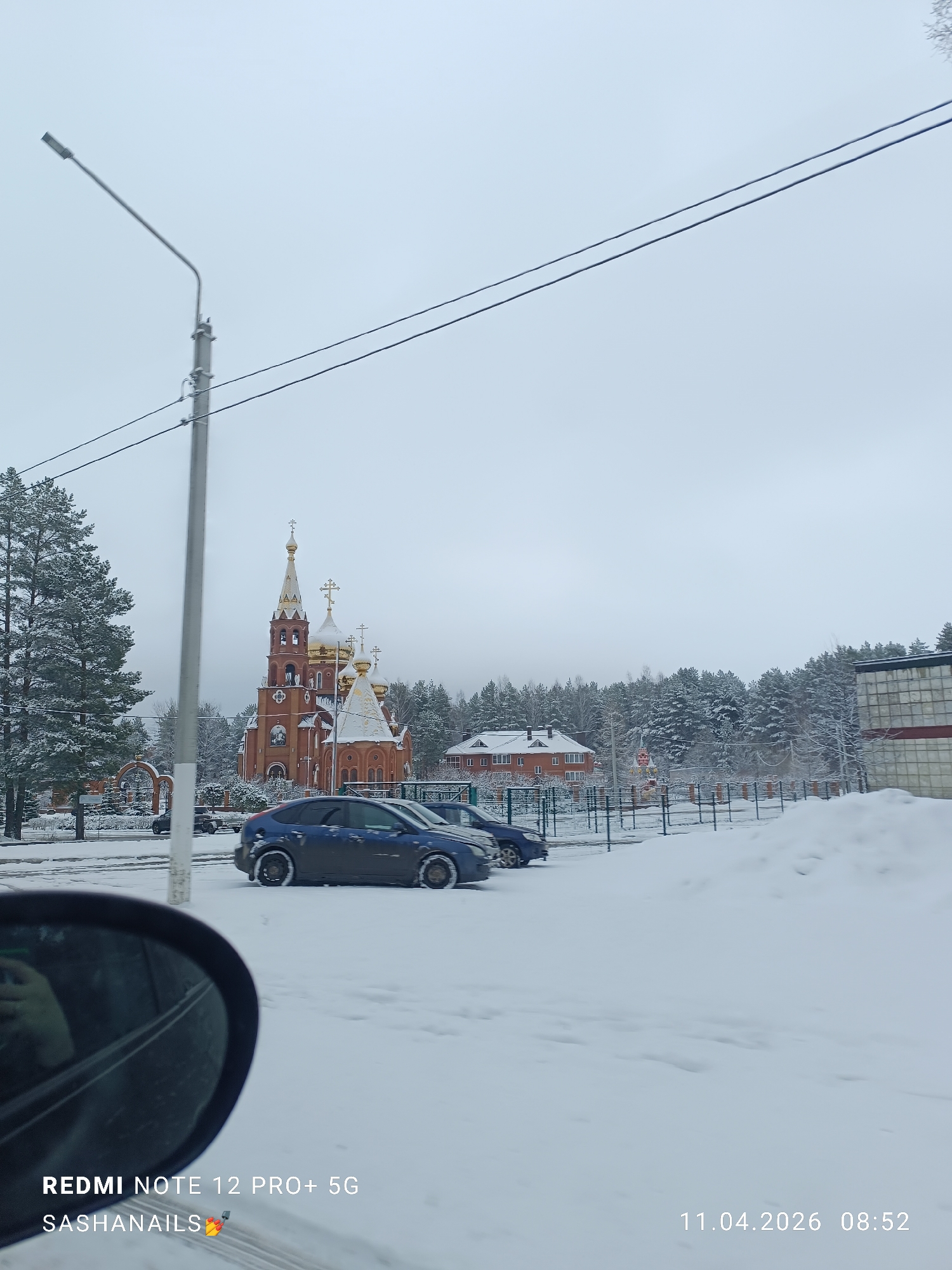Snowy cityscape with golden-domed building captured from vehicle