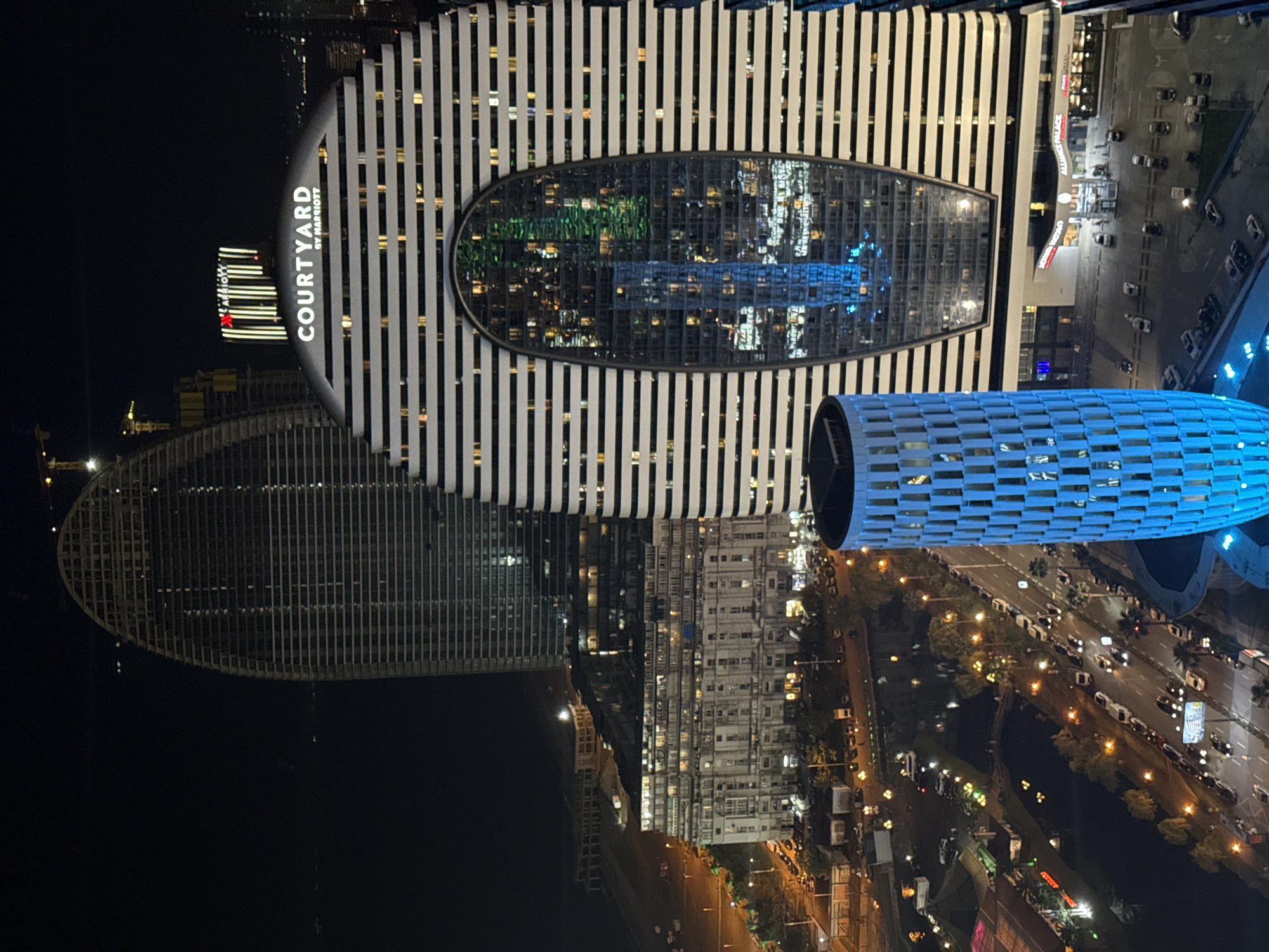 Batumi's lit-up skyline and coastline from the air at dusk