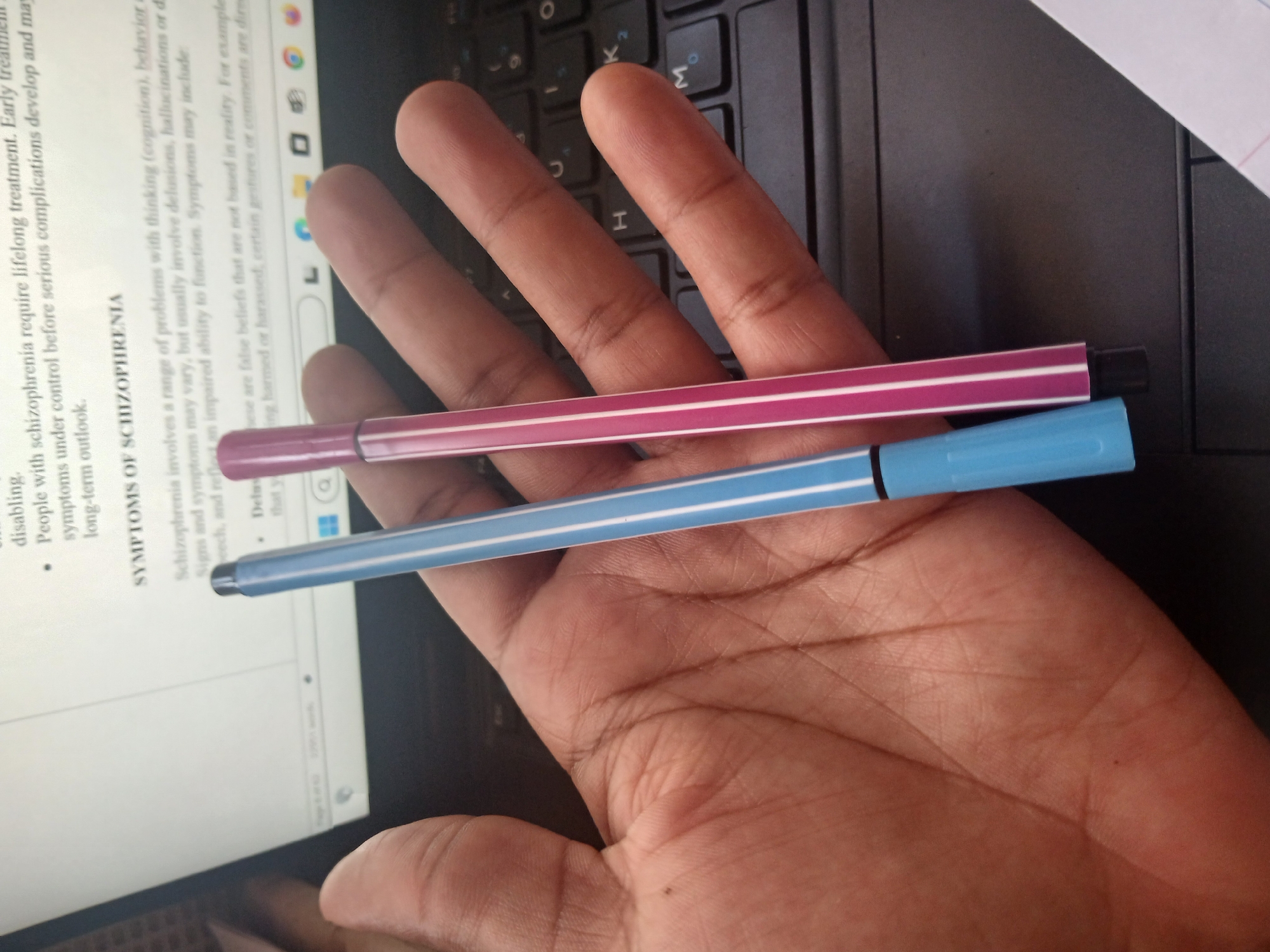Person uses laptop with pens, hair product in Kenya