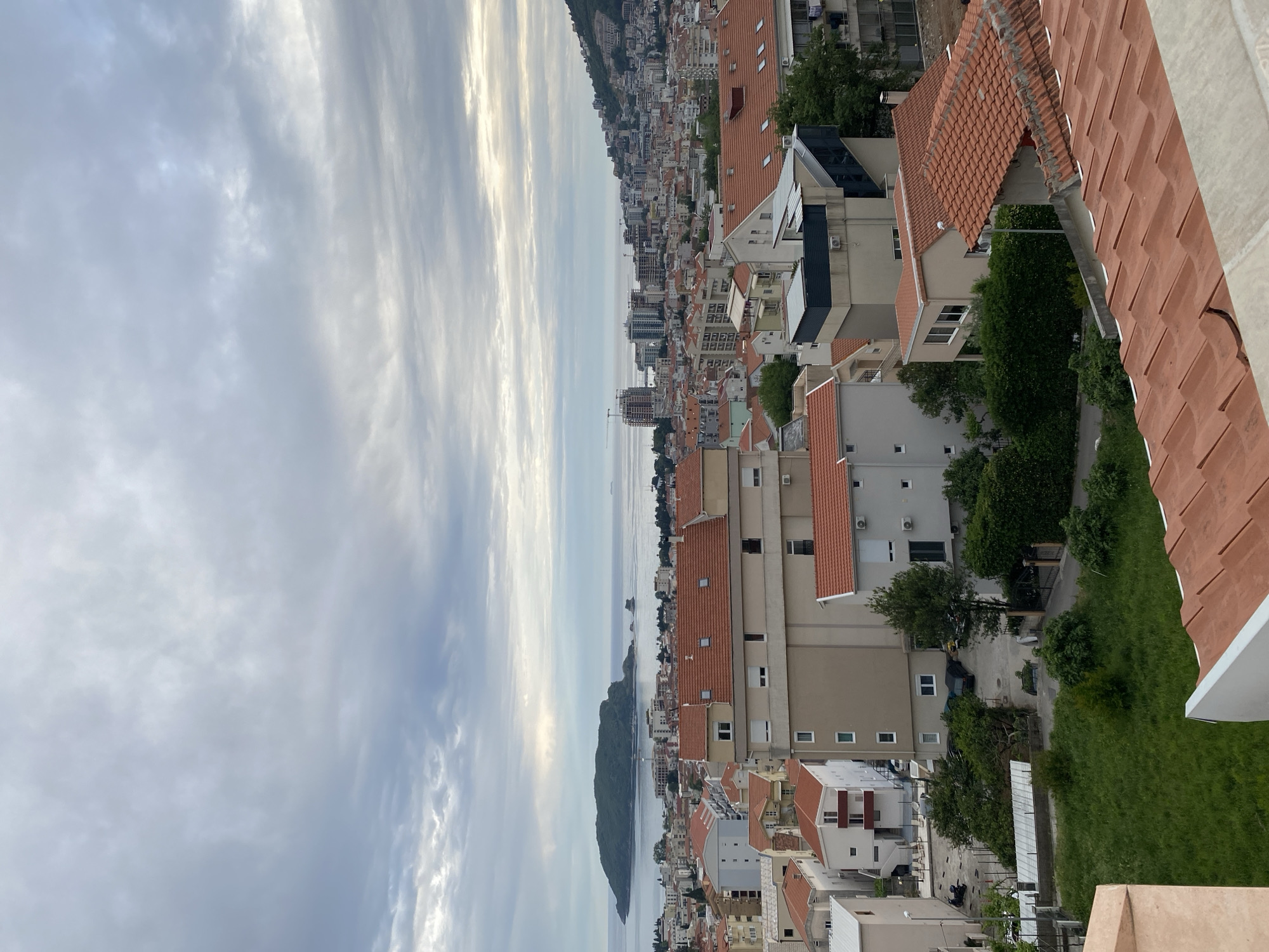 Aerial views capture Budva's coastline and architecture under cloudy skies