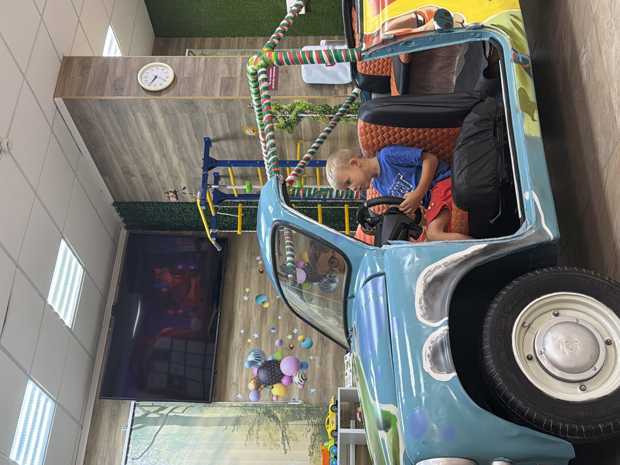 Kid in toy car, waiting area vibes at a Sochi play venue