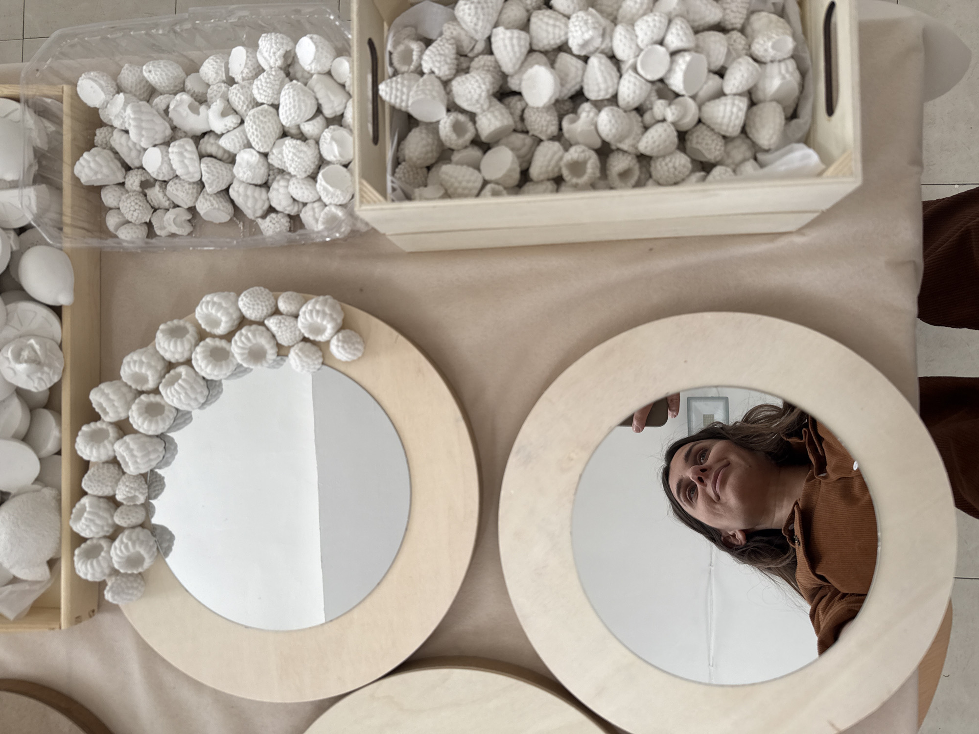 Handcraft display features wooden mirrors and plaster fruits in Tel Aviv