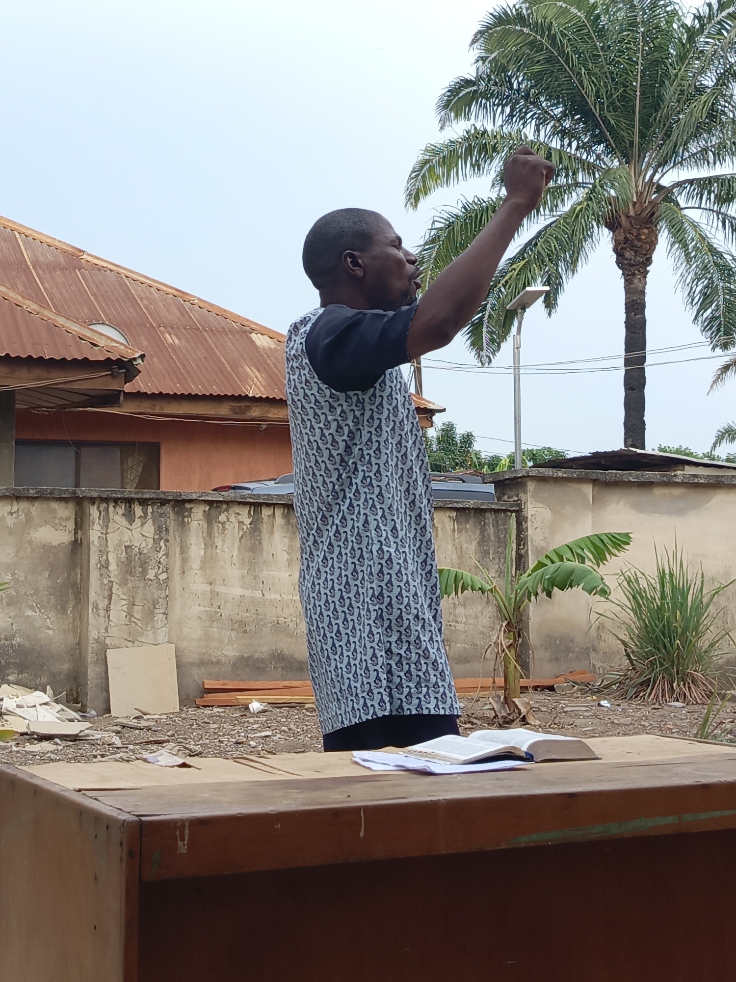 Man delivers outdoor sermon in Akwanga courtyard