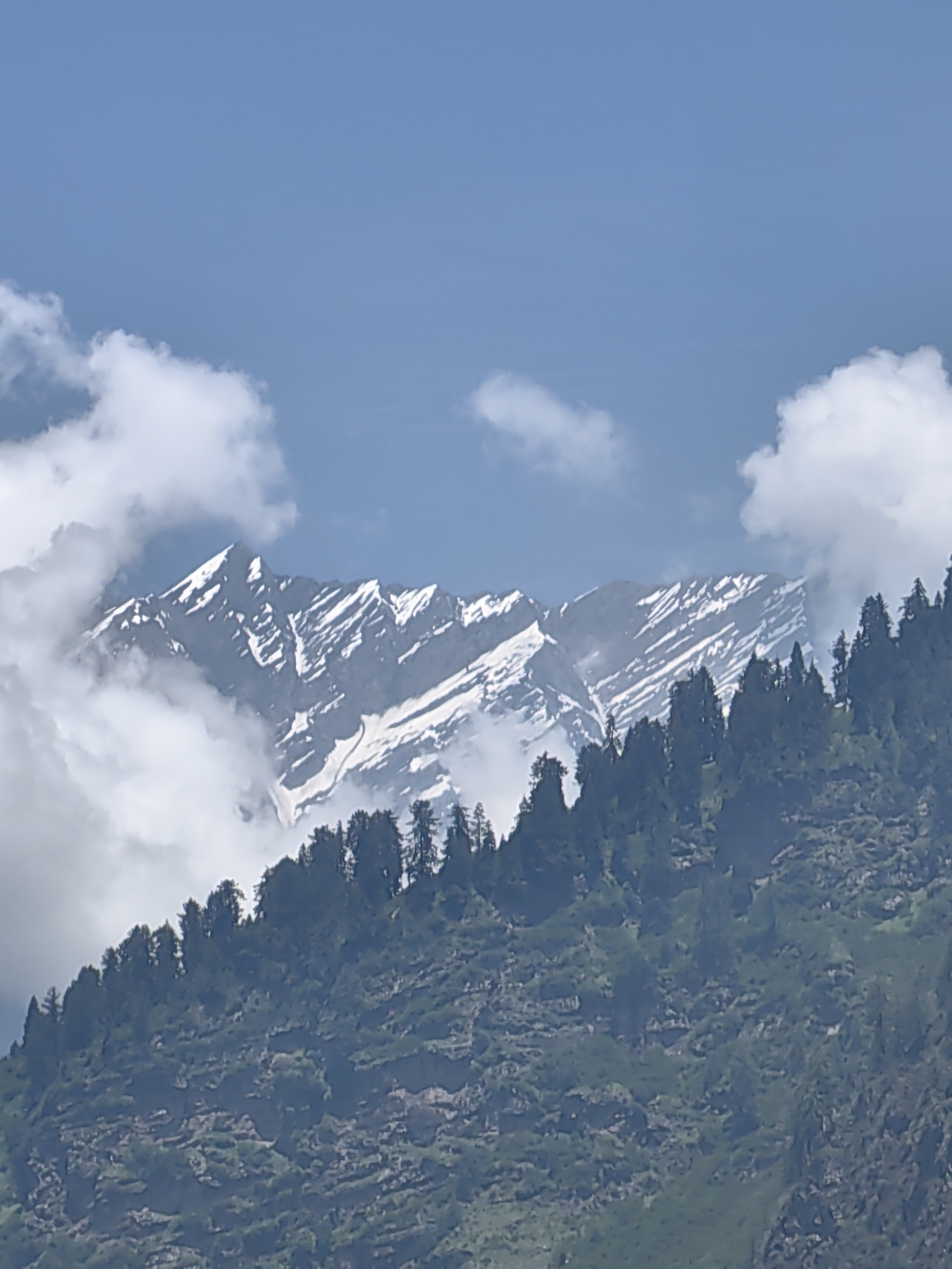 Cloud-wrapped Himalayan peaks near Kulang on a clear morning