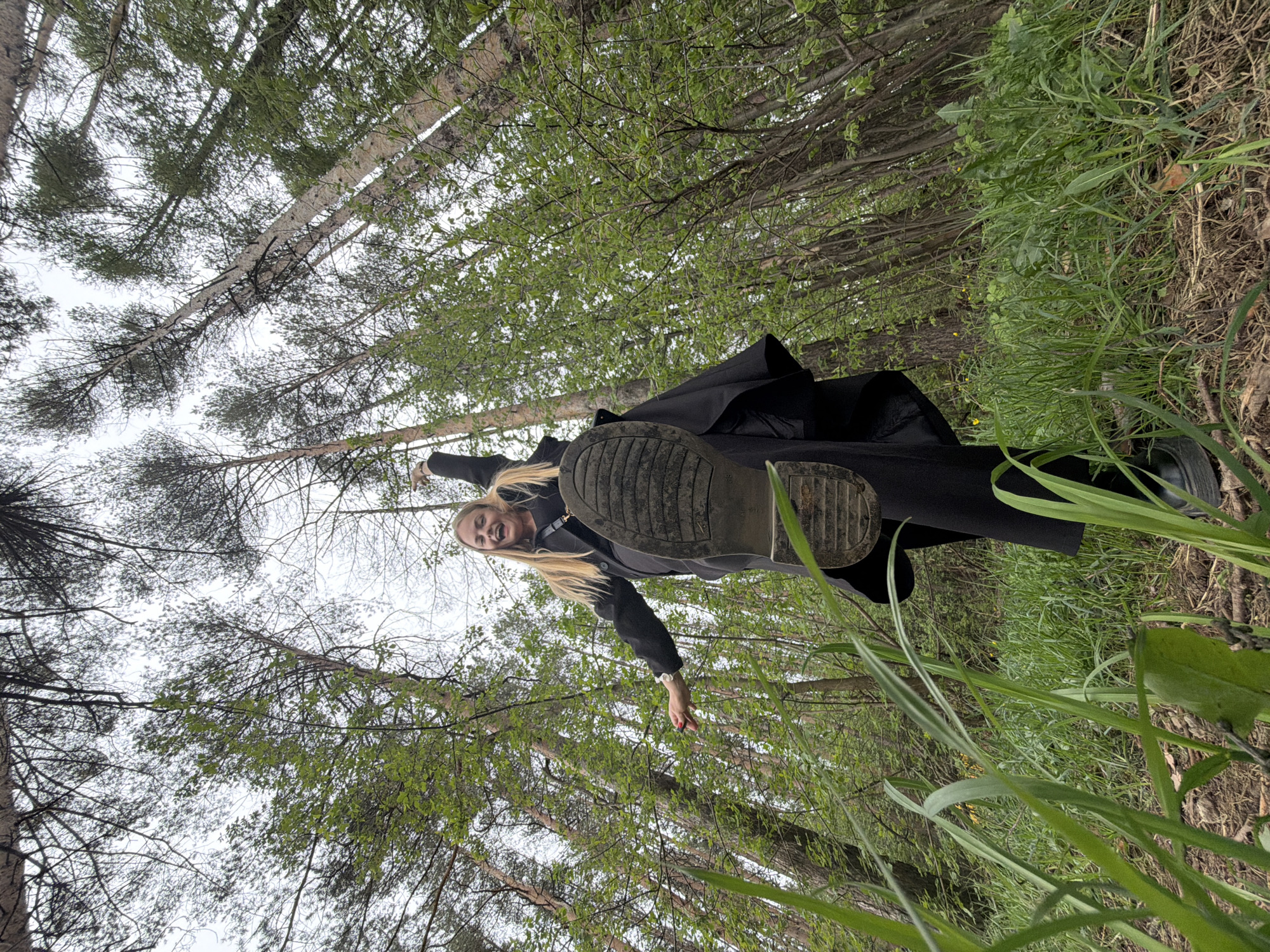 Woman photographs herself in Izhevsk forest during morning outing