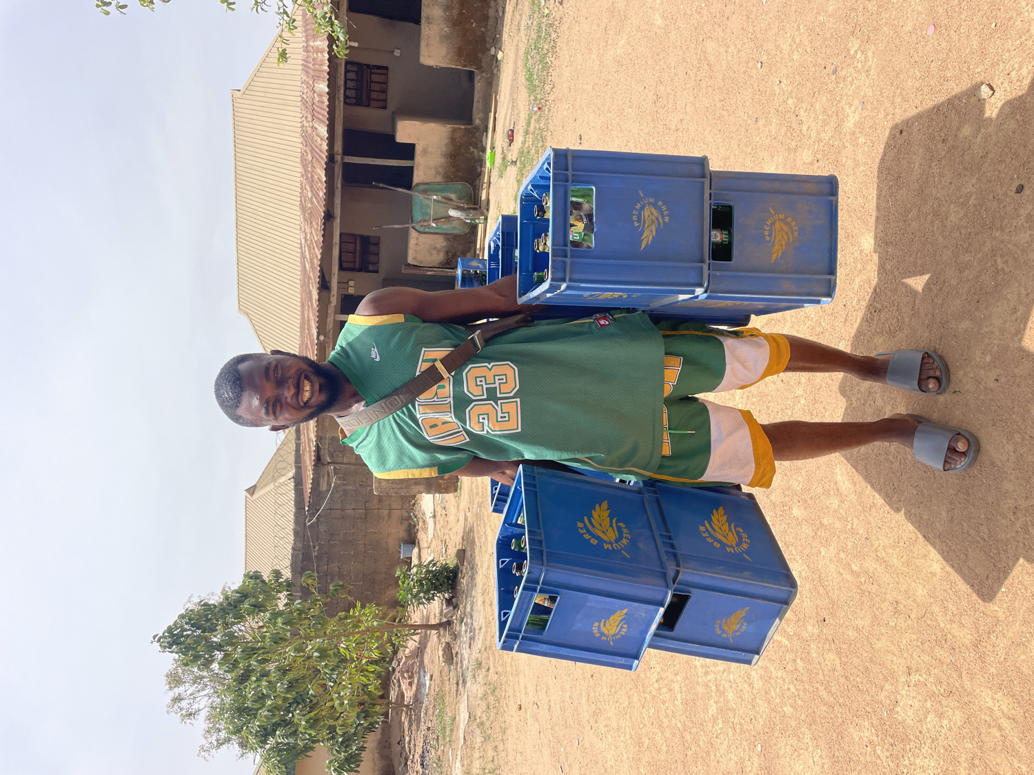 Man carries plastic crates in sunny Barakin Akawo