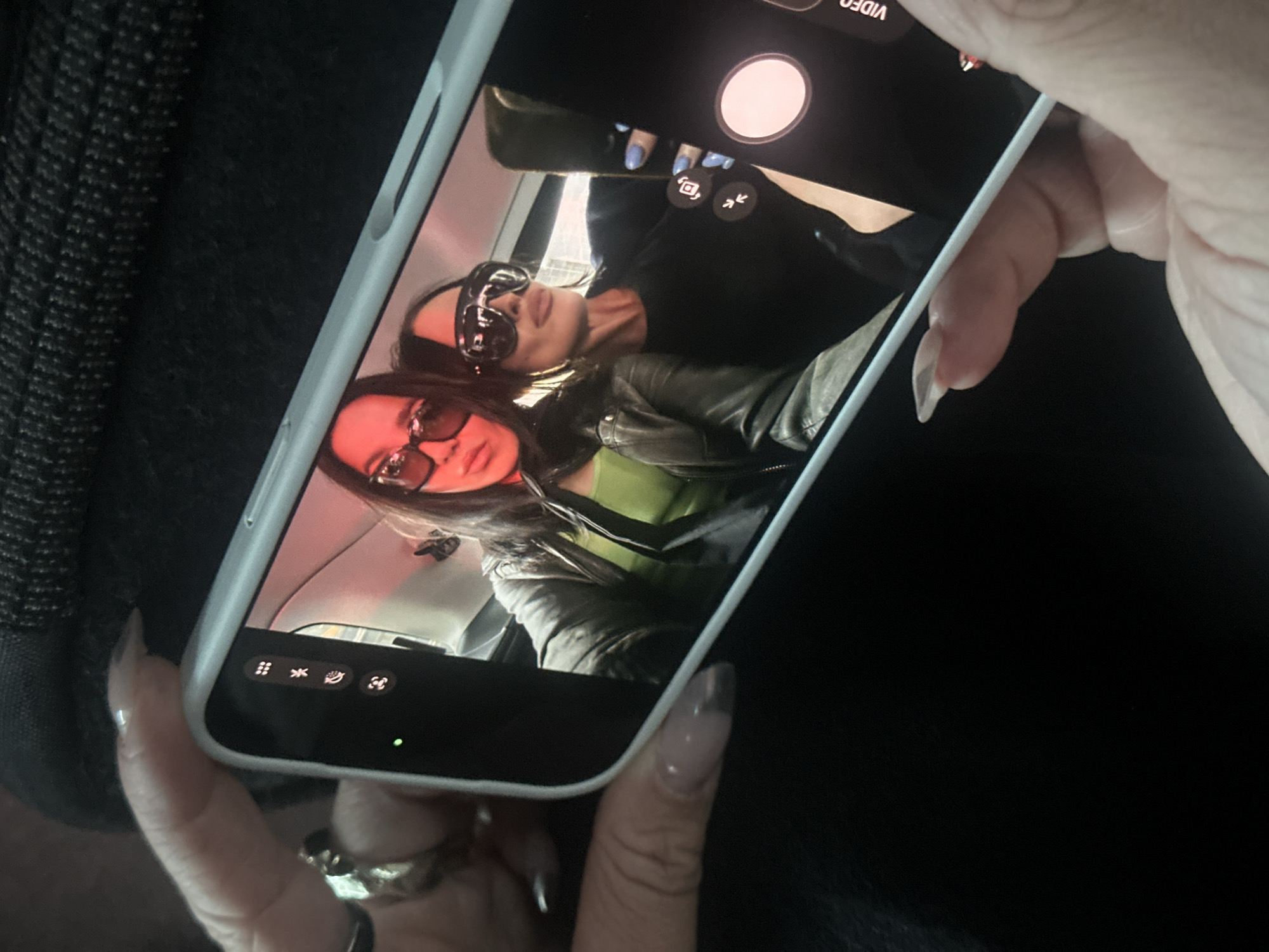 Person photographed holding white iPhone in London