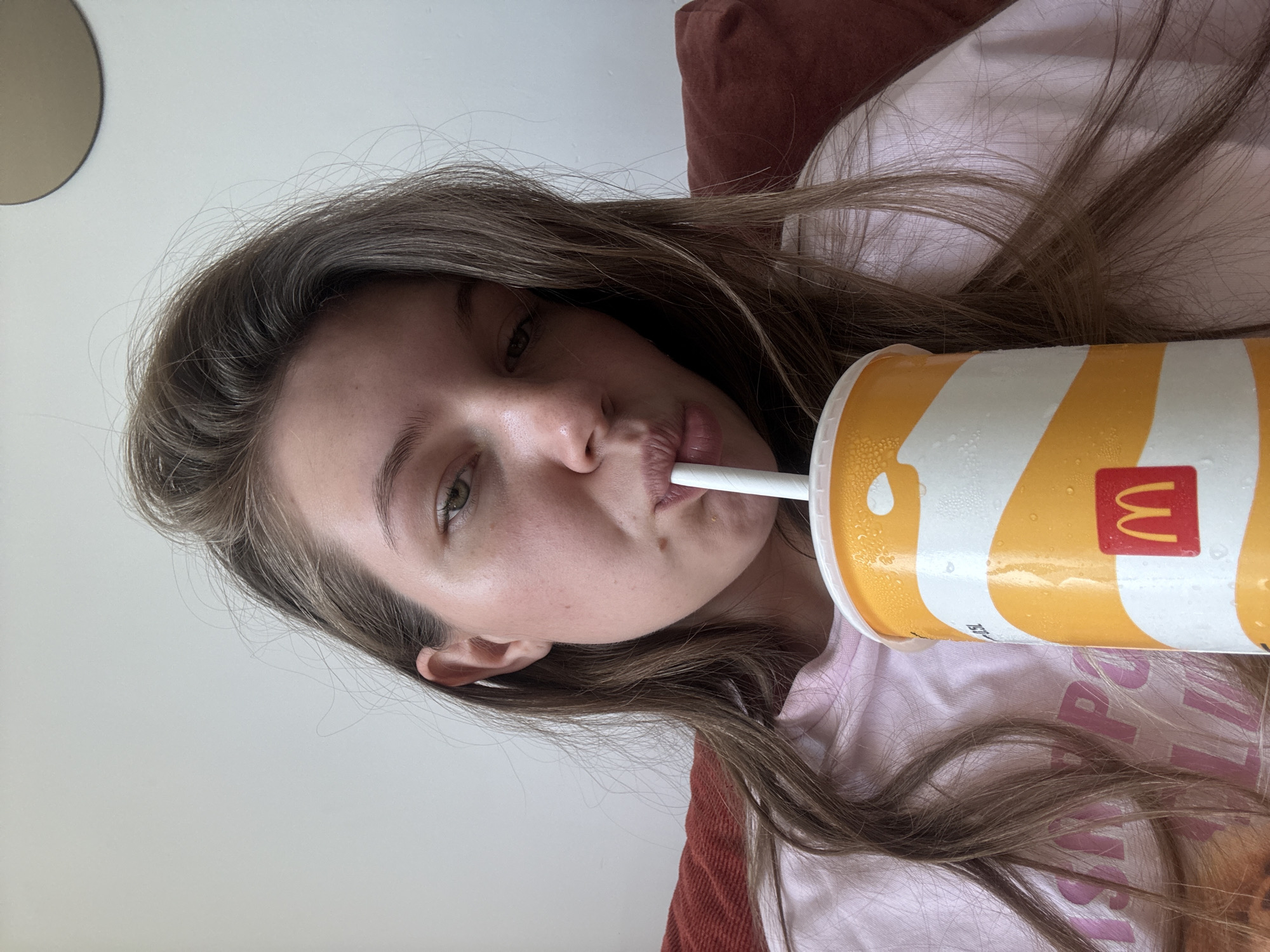 Woman drinks McDonald's beverage while resting in Belgrade suburb